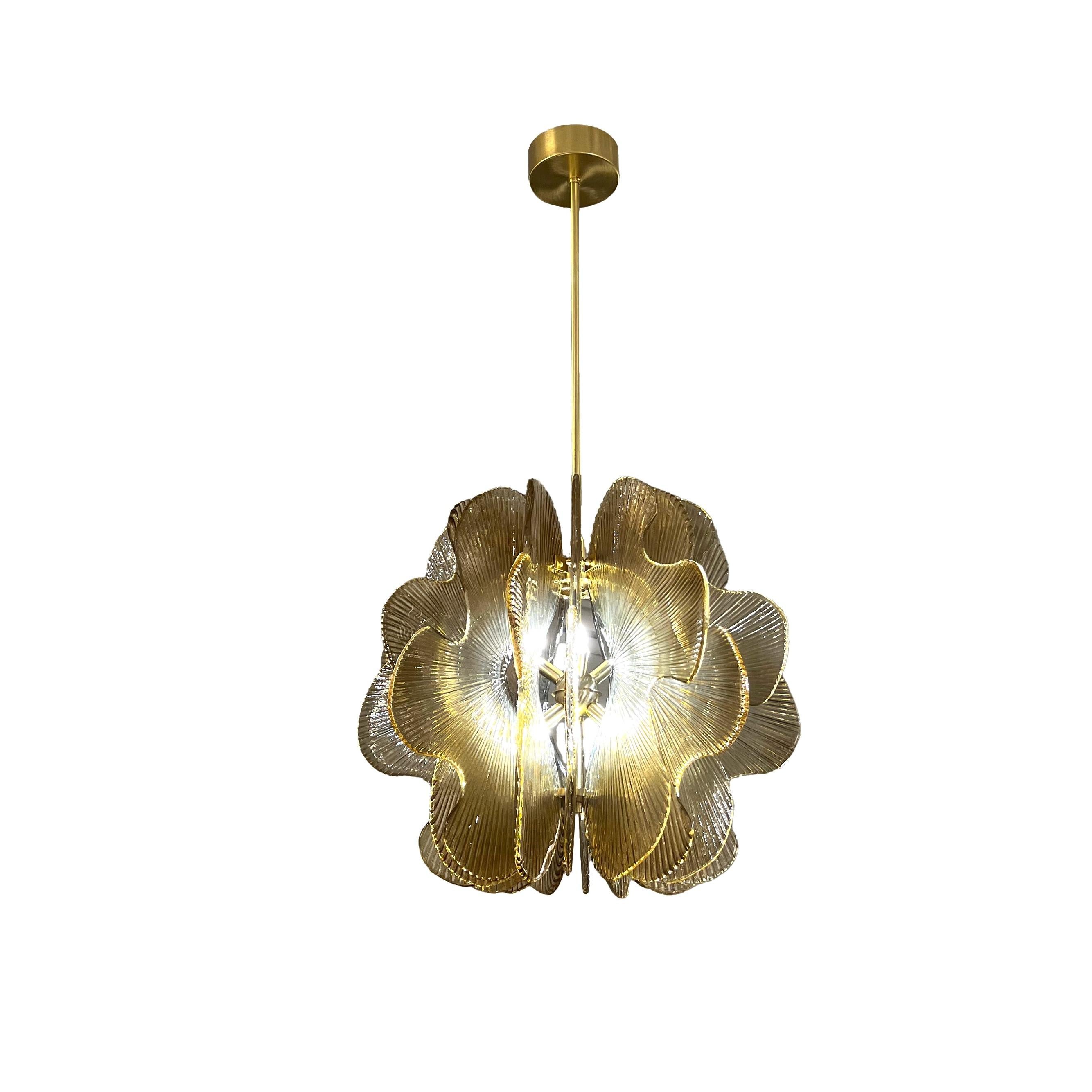 A post-modern playful suspension couture light fixture, a creation entirely handcrafted in Italy with floral stylized shape, the satin brass structure decorated all around with 16 jutting stylized petal flower curvy slabs in textured Murano glass,