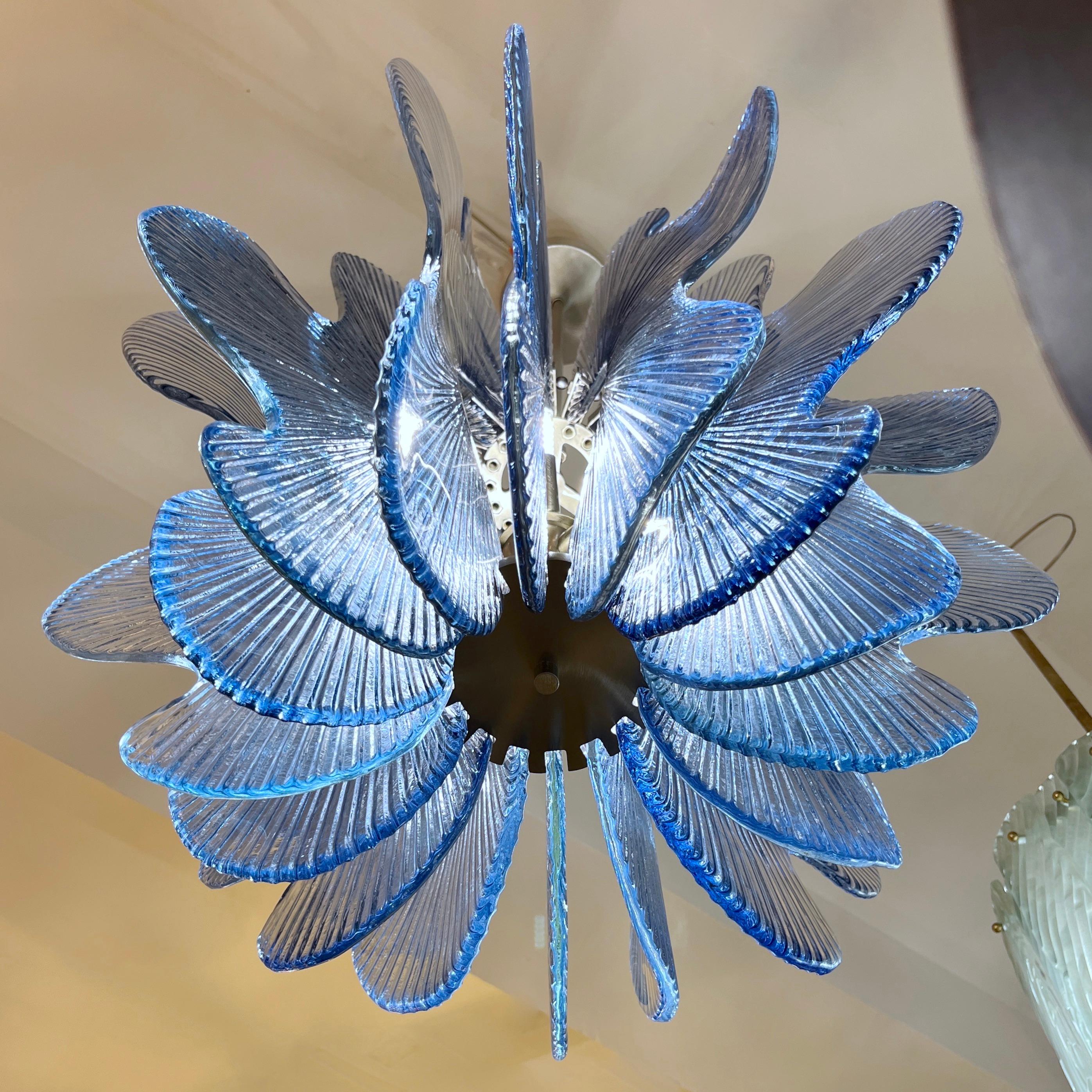 Un luminaire post-moderne à suspension ludique, une création entièrement réalisée à la main en Italie avec une forme florale stylisée, la structure en nickel satiné décorée tout autour de 16 dalles en forme de pétales de fleurs stylisées en verre de