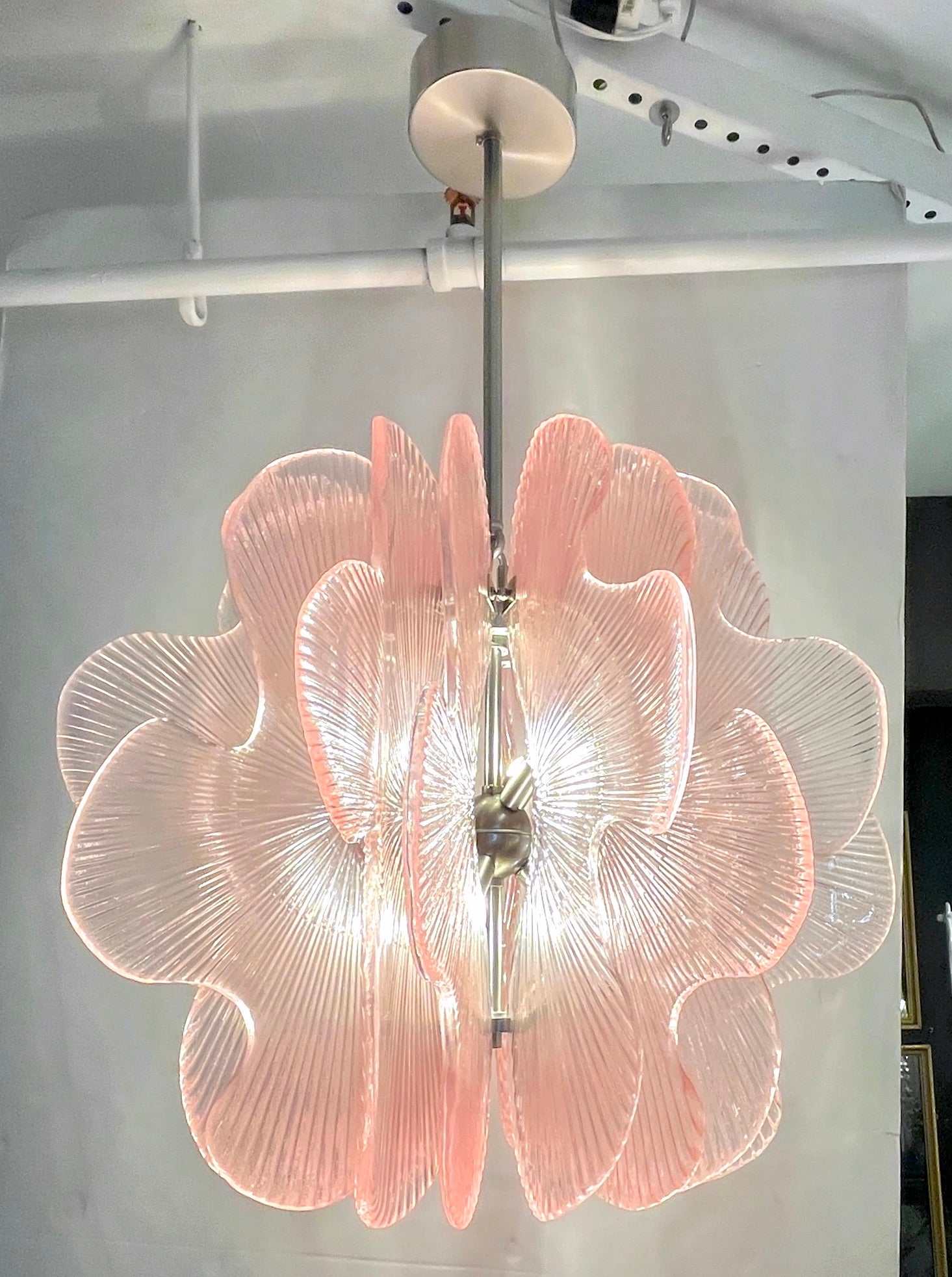 Un luminaire post-moderne à suspension ludique, une création entièrement réalisée à la main en Italie avec une forme florale stylisée, la structure en nickel satiné décorée tout autour de 16 dalles en forme de pétales de fleurs stylisées en verre de