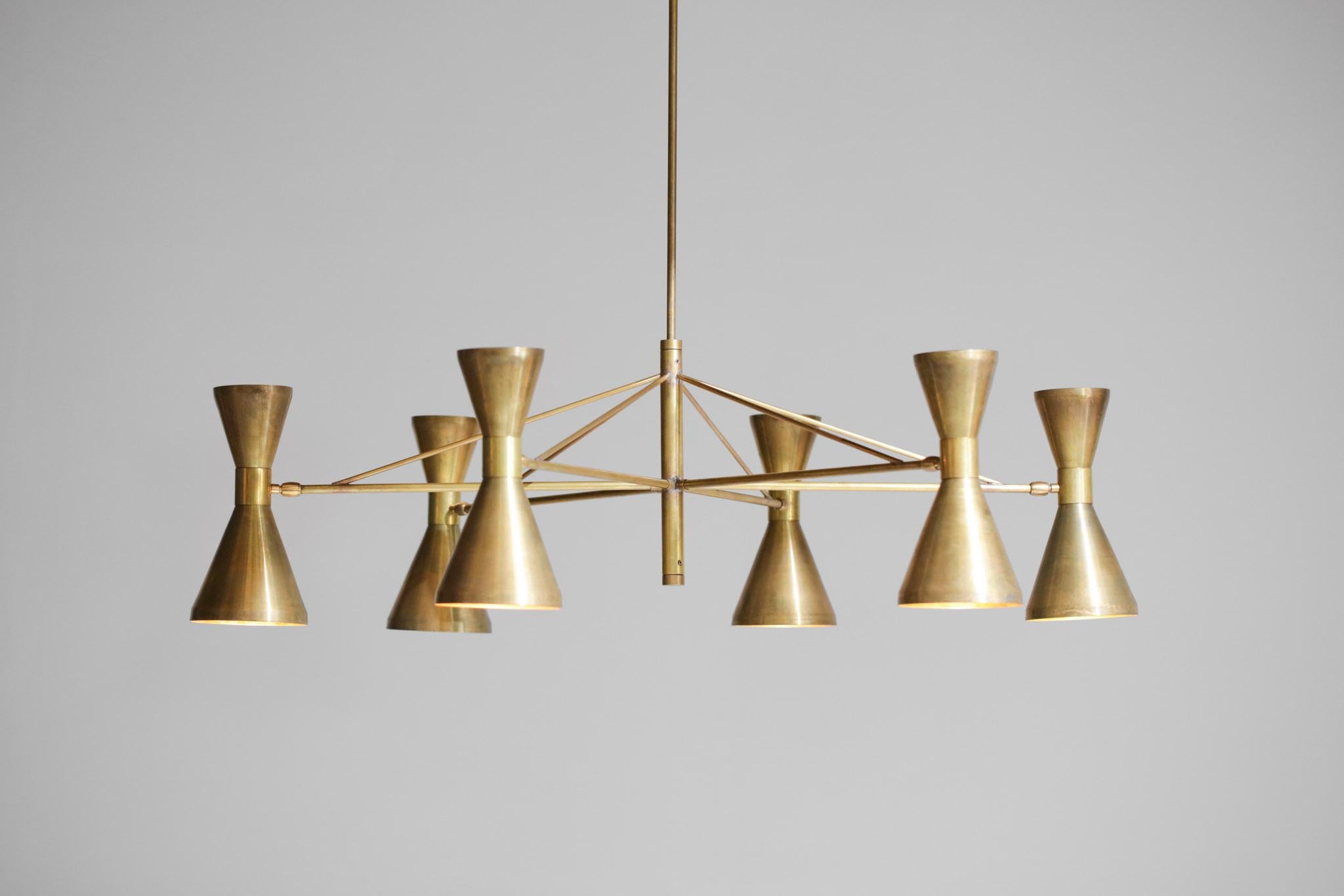 Beautiful modern Italian chandelier, handcrafted. Geometrical structure in solid brass with six arms connected by a central axis. All the Diabolo shades are made of brass and can be adjusted according to your needs. Very nice light and shadow effect