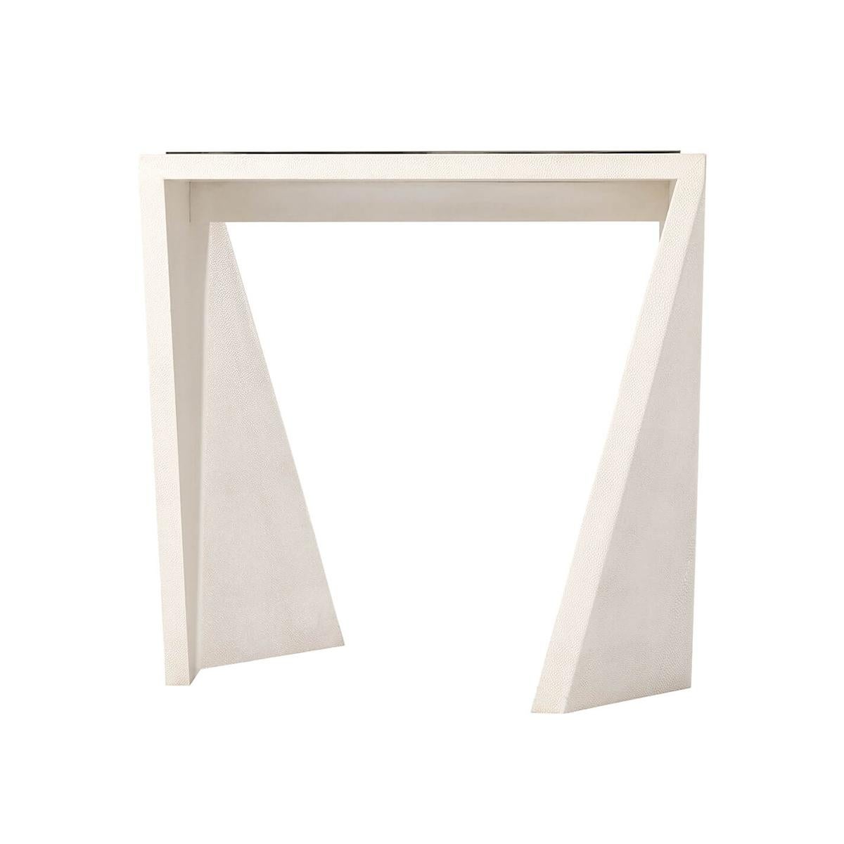  un cuir ivoire gaufré de galuchat enveloppant une table d'appoint moderne modulaire dont le plateau rectangulaire est orné d'une galerie moulée nickelée. La forme de la base est une forme géométrique angulaire irrégulière.

Dimensions : 24