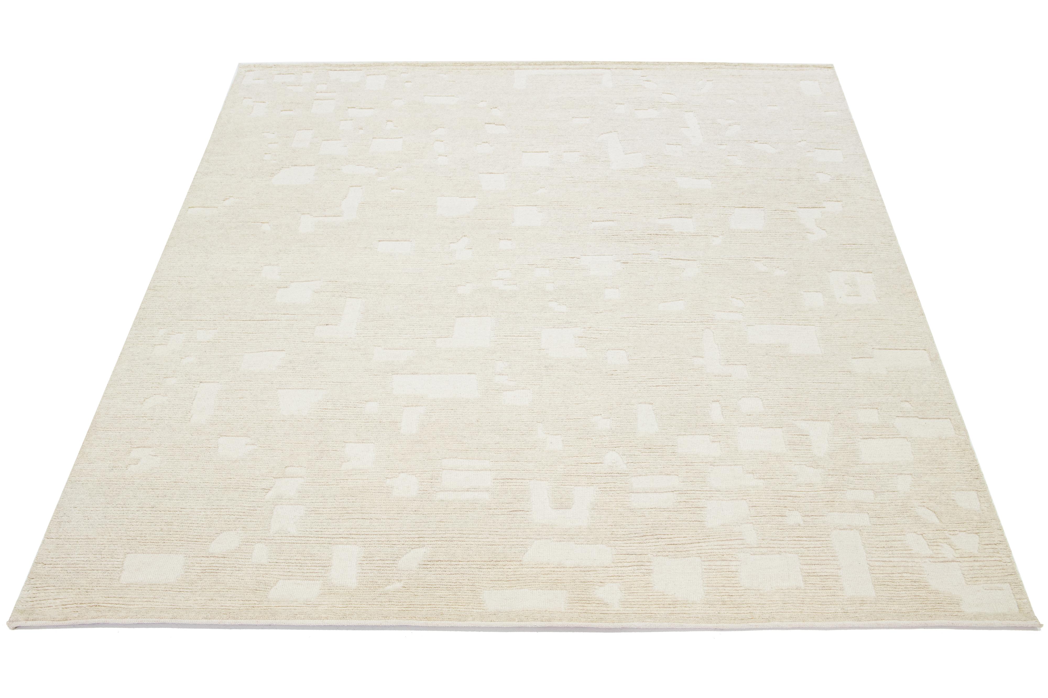 Featuring a contemporary design on a natural ivory background, this hand-knotted Moroccan-style wool rug beautifully showcases a mesmerizing minimalist aesthetic.

This rug measures 8'1