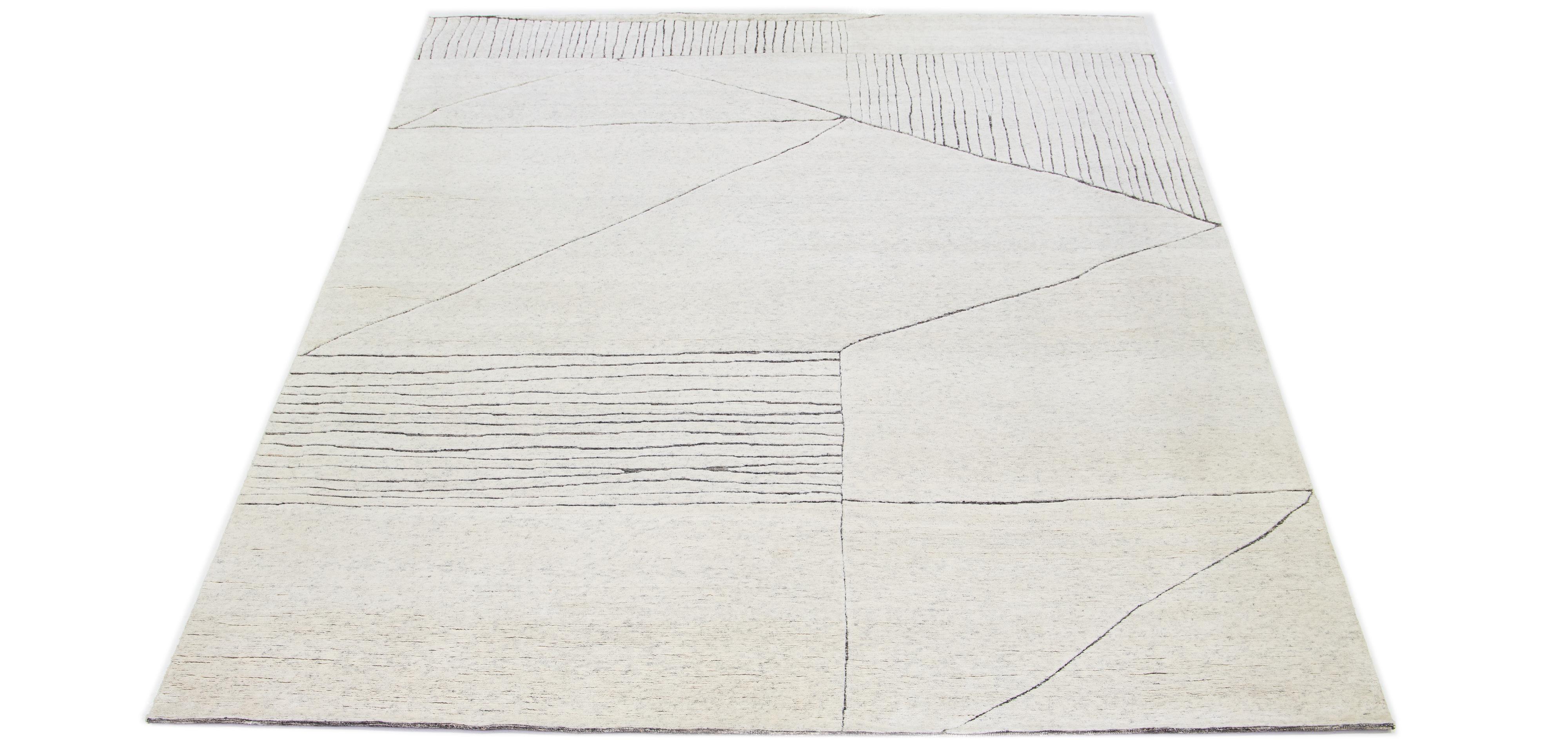 This luxurious wool rug features a timeless Moroccan pattern in a contemporary abstract Minimalist style, utilizing beige tones to create a sleek and modern look. It is crafted using traditional hand-knotting techniques, ensuring exceptional quality