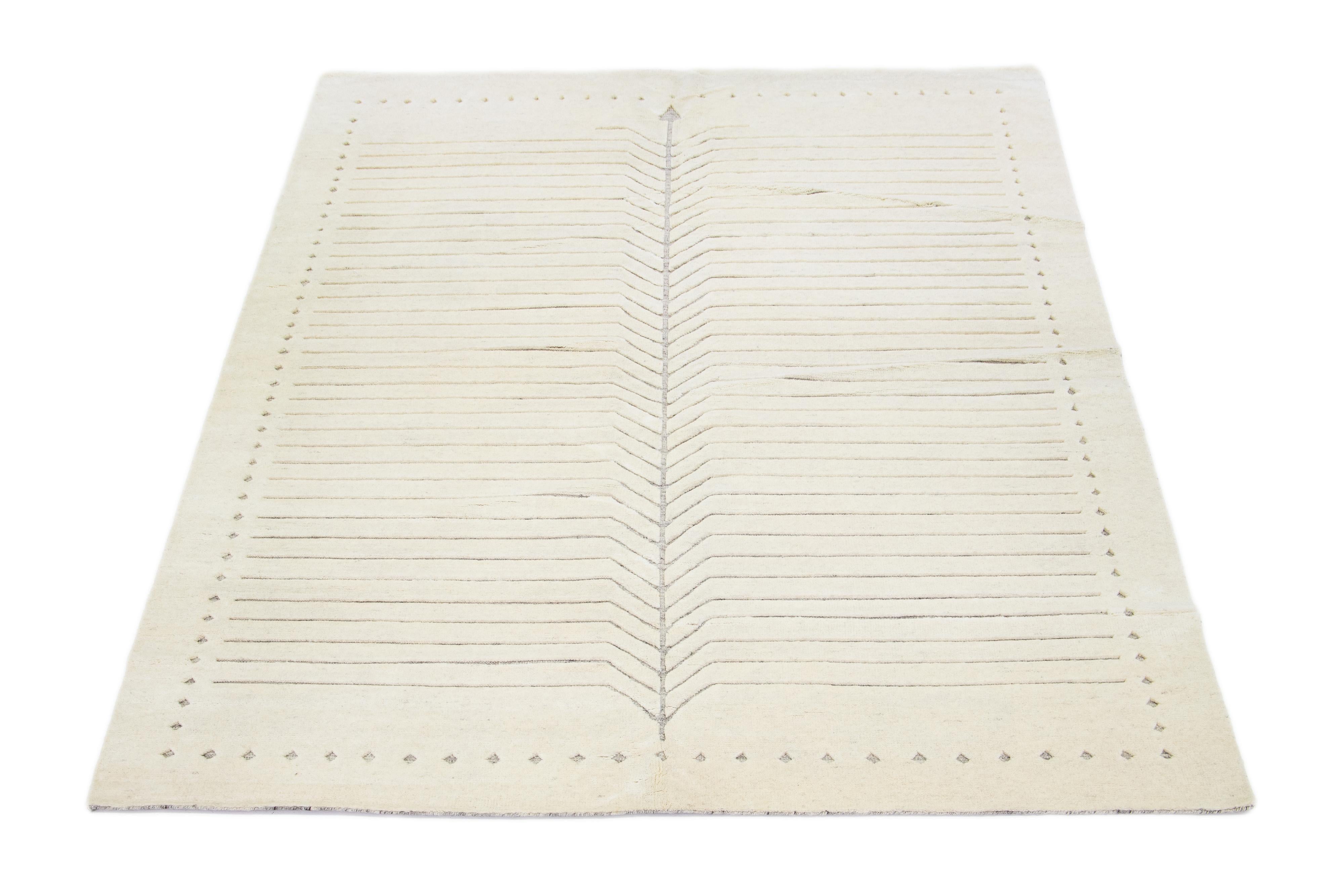 Exquisitely crafted by hand, this modern Moroccan rug features a luxuriously minimalist gray design in the most elegant ivories.

This rug measures 9' x 12'.