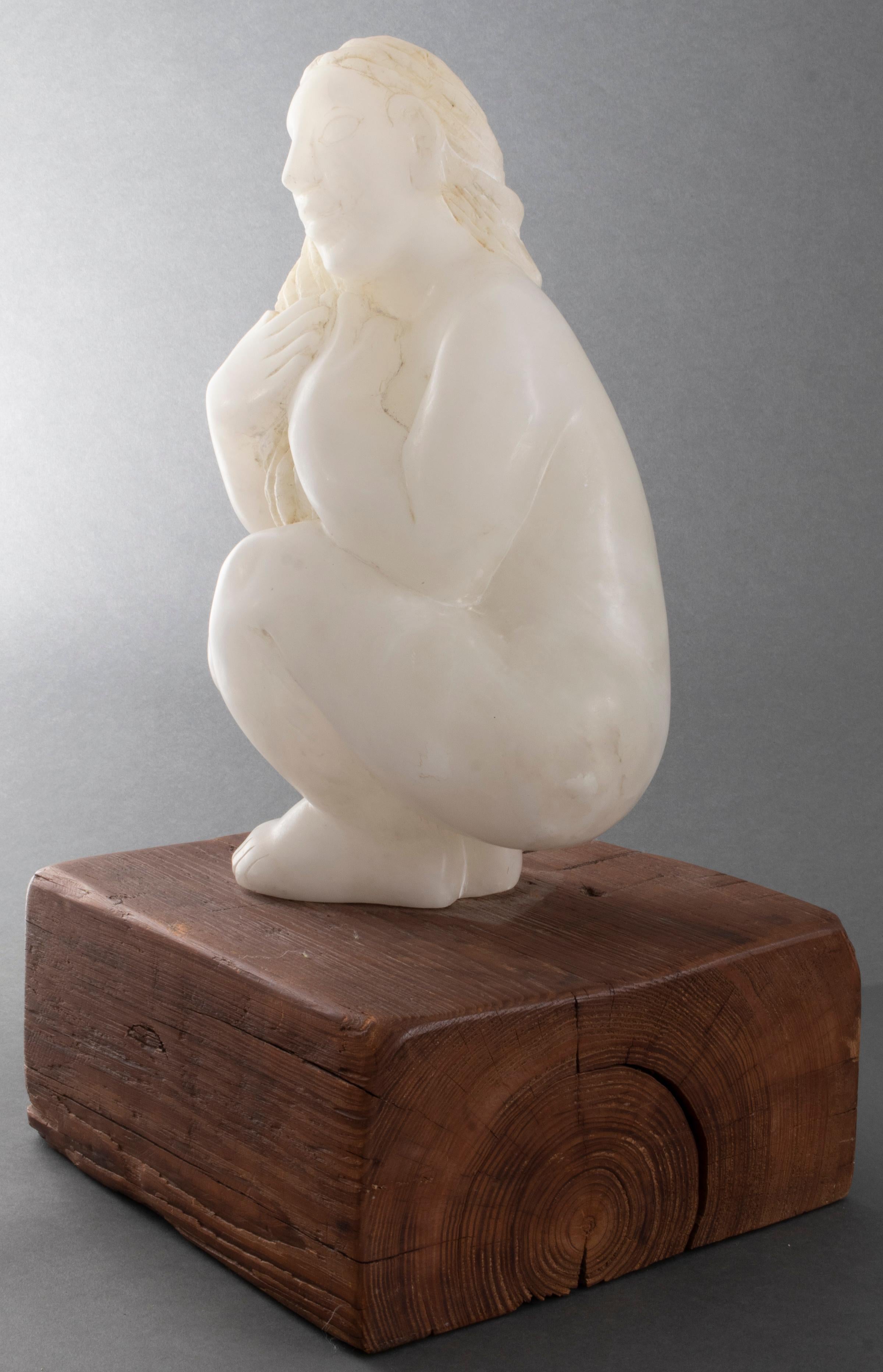 Modern carved alabaster sculpture of a crouching woman, signed to back leg 