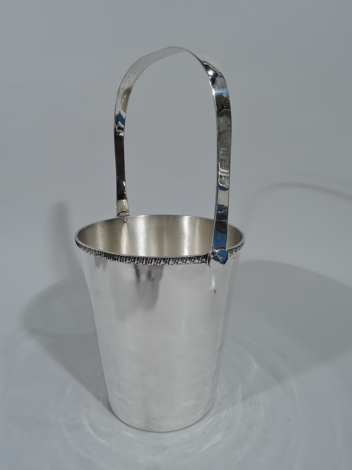 Modern Japanese 950 silver ice bucket. Straight and tapering sides and swing u-form handle. Rim has alternating flutes and beading. Hallmarked “Silver Sterling 950”.

Dimensions: H (without handle) 6 1/4 x D 5 1/2 in. H (with handle) 12 in.