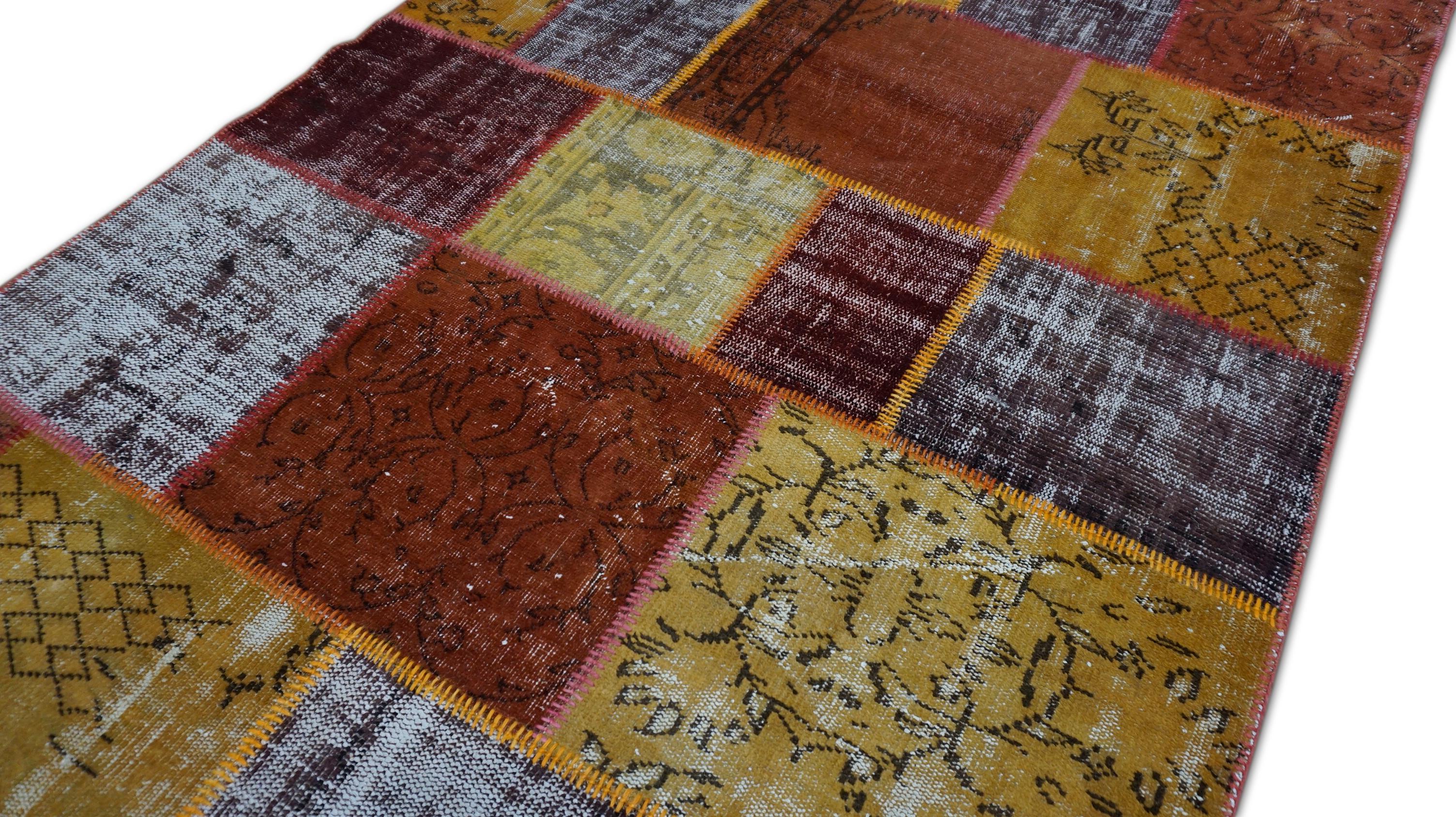 Dieser auffällige, handgewebte Wollteppich ist ein lebendiges Beispiel für die Kunstfertigkeit der Region und besteht aus einer gefärbten Patchwork-Komposition, die aus alten Teppichfragmenten zusammengesetzt ist. Der Teppich zeigt ein kühnes