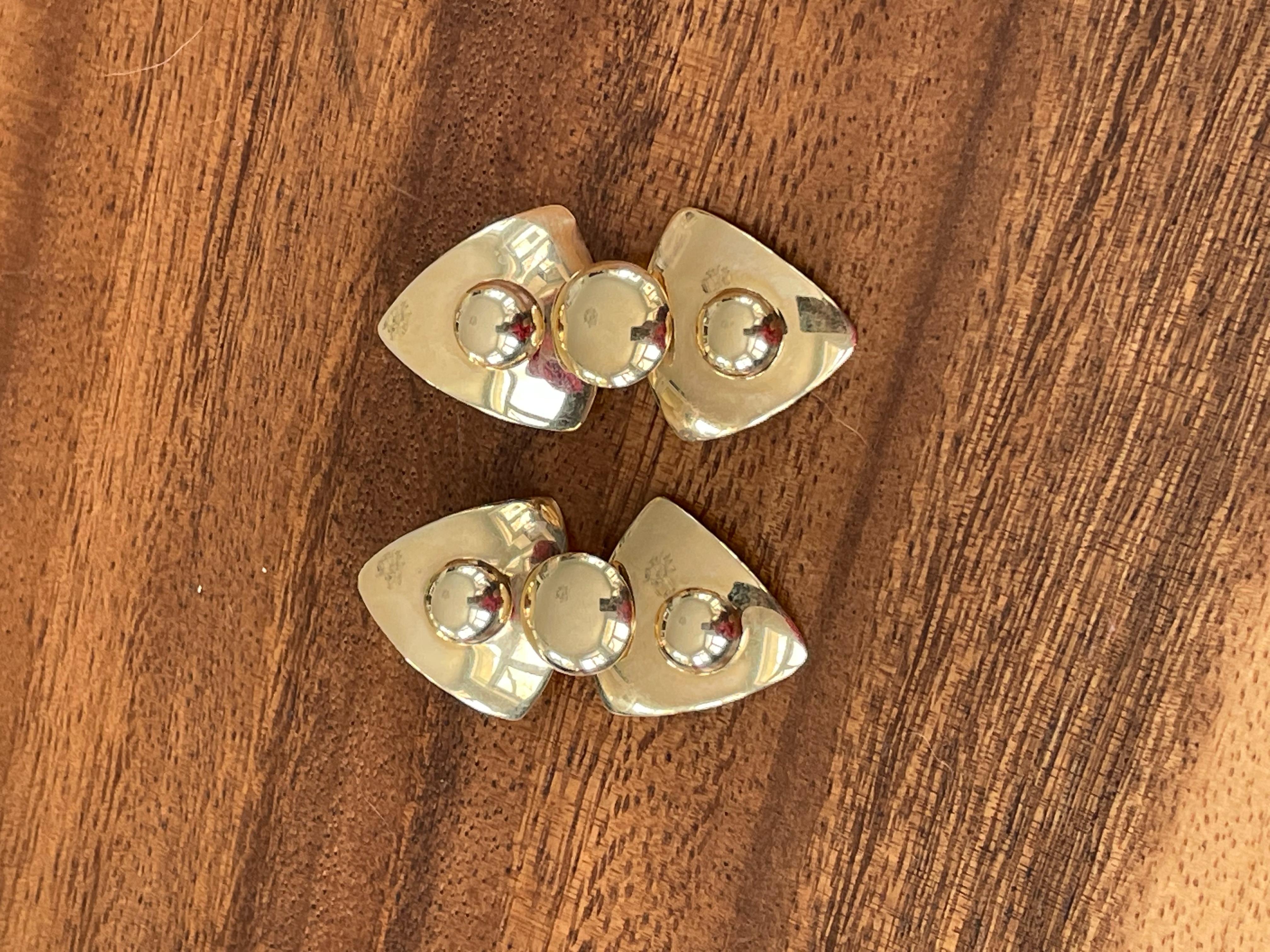 These stamped John Atencio (JA) pierced earrings are of a modern design.  They are 14 karat yellow Gold.  The lower piece is articulating providing for light reflection and an additional eye-catching feature.  

Measurement:  1 3/4
