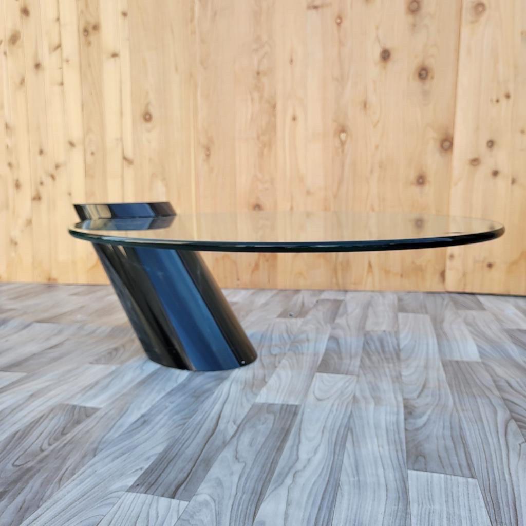 Modern Karl Springer style cantilevered glass cocktail table

Karl Springer style modern cantilevered glass surface cocktail or coffee table. The piece consists of a slanted black column with an oval glass top cantilevered into a wedge.

Circa
