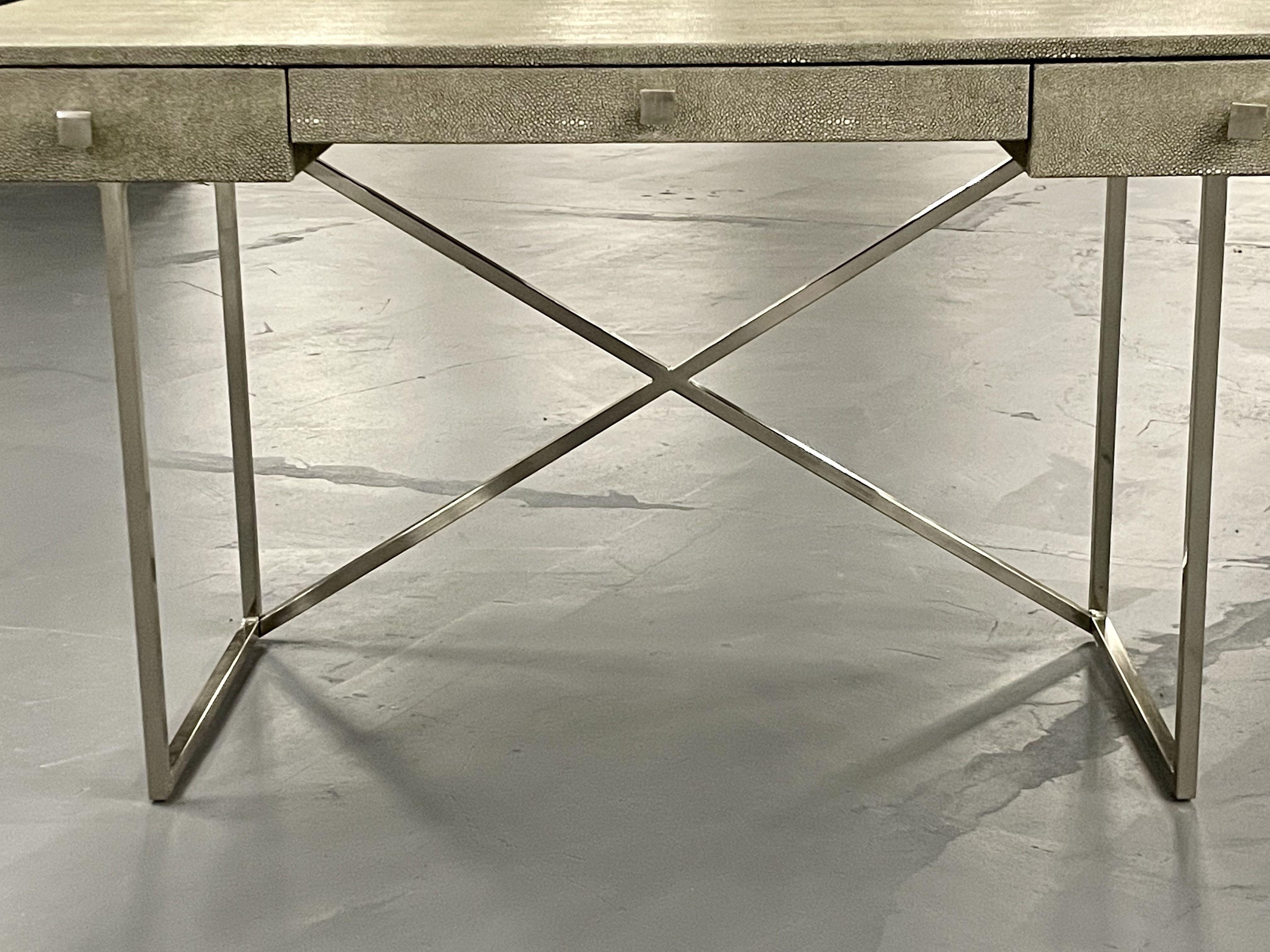 Modern Karl Springer style three-drawer faux Shagreen desk on a chrome plated x form base.
Sleek desk or writing table in a Springer style finish with a chrome X form base leading to a finely detailed table top.