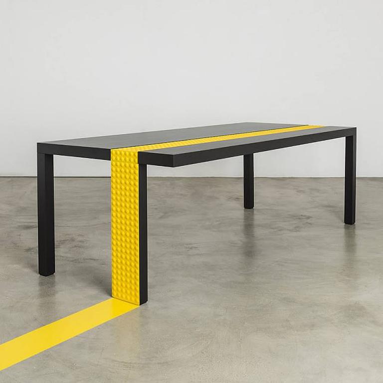 Rectangular dining table made in soft lacquered black finish. The special yellow detail is the tactile orientation line formed by LOGES semi-spherical caps and is engraved along the entire length of the top and of one leg.
Signed by the