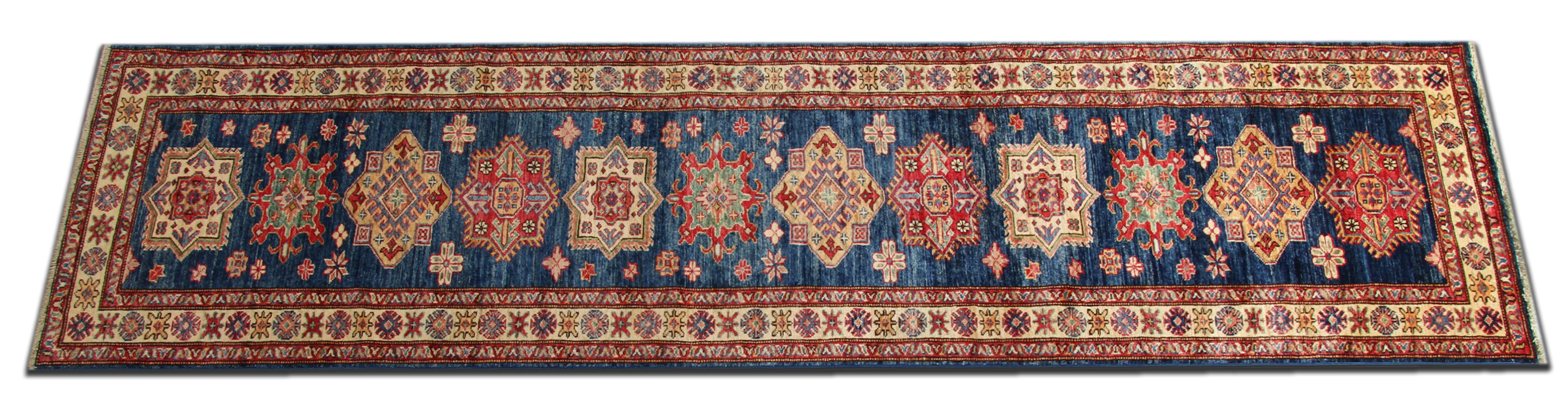 This handmade flat-weave motif rug comes in a striking color combination. This blue rug has bright red, navy, light blue, sea blue, cream and caramel colors. The pattern depicted on this woven rug has been influenced by
Caucasian designs. This New,