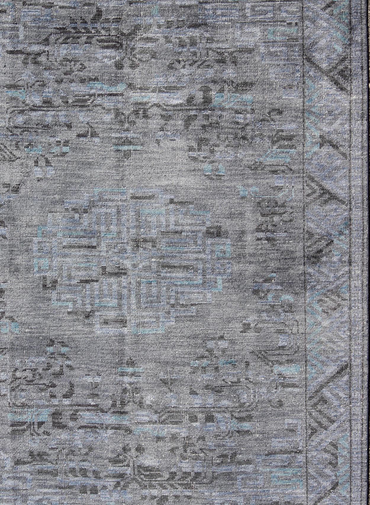 Khotan design modern rug with blue, gray, brown and charcoal and center medallion design, Keivan Woven Arts/ rug/ OB-9516698, country of origin / type: Khotan

This hand knotted Khotan rug features a beautiful center medallion design rendered in