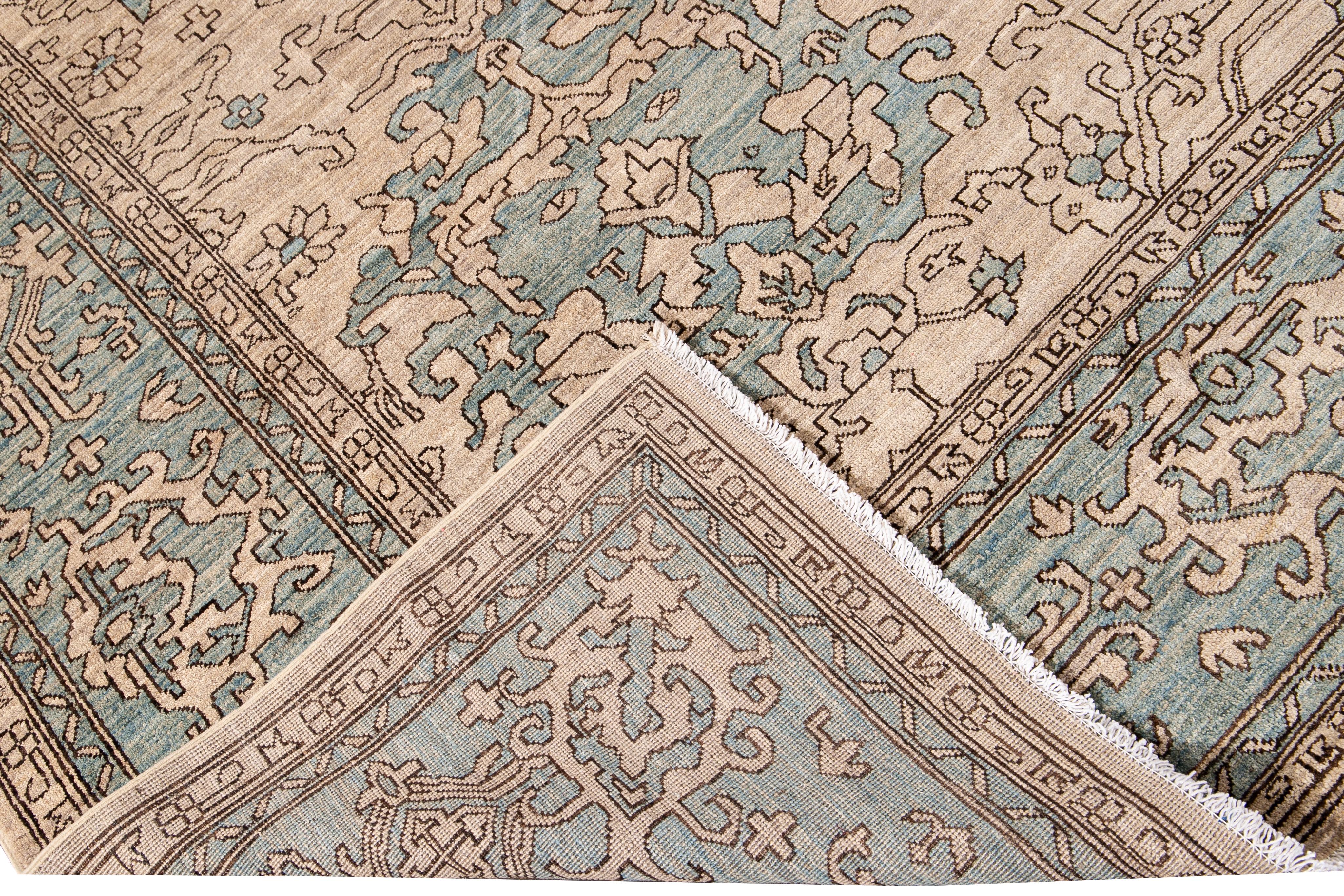 Beautiful modern oversize Khotan hand-knotted wool rug beige field. This Khotan rug has a beautifully designed frame and accent of blue in a gorgeous all-over geometric medallion floral design.

This rug measures 10'5