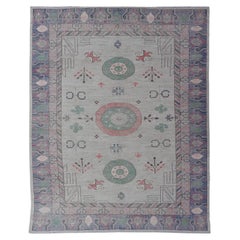 Tapis moderne Khotan avec médaillons circulaires en vert clair, violet et saumon