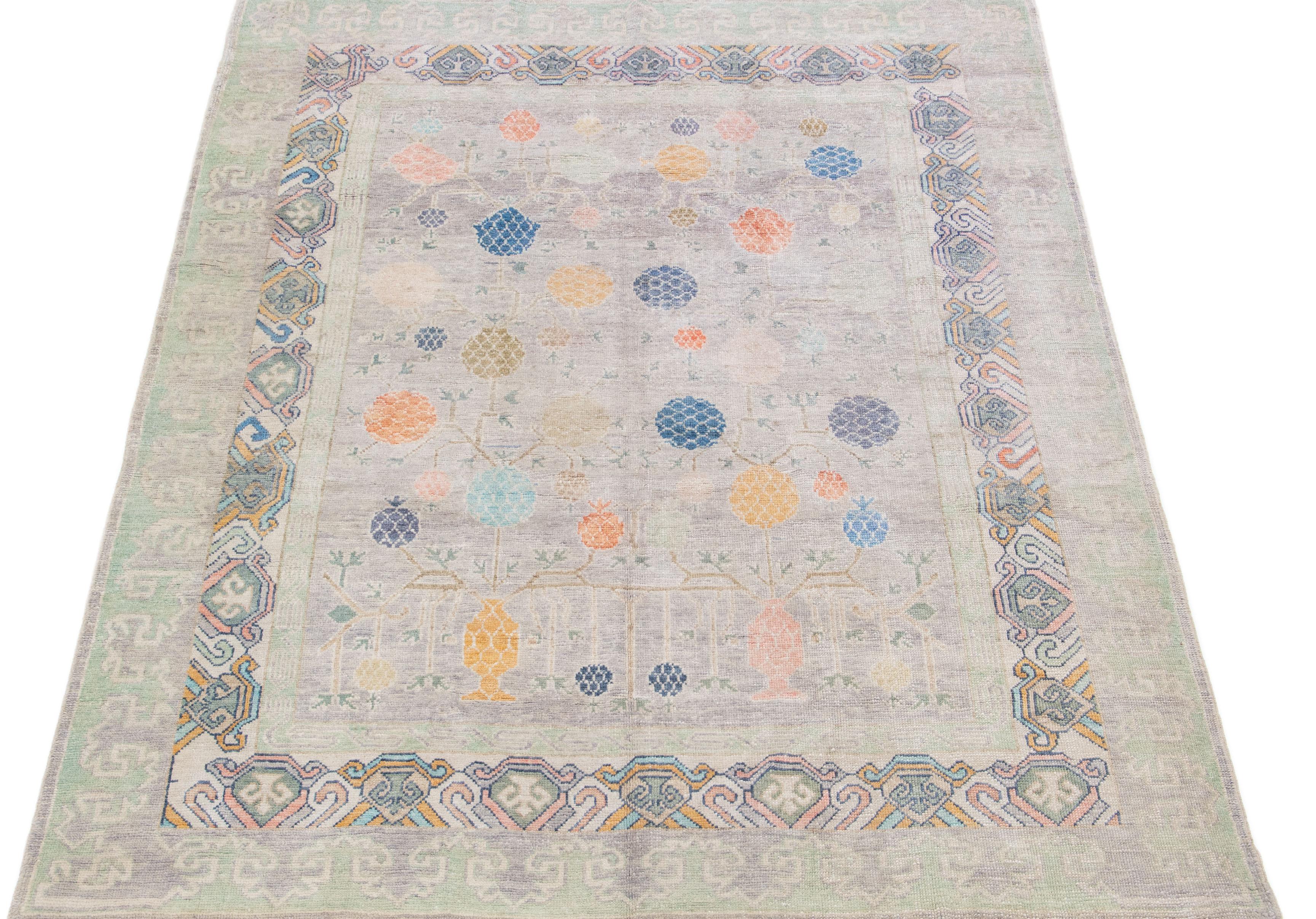 Beautiful modern Khotan-Style hand-knotted wool rug with a gray field. This piece has a green frame and multicolor accents in a gorgeous all-over floral pattern design.

This rug measures: 8'4