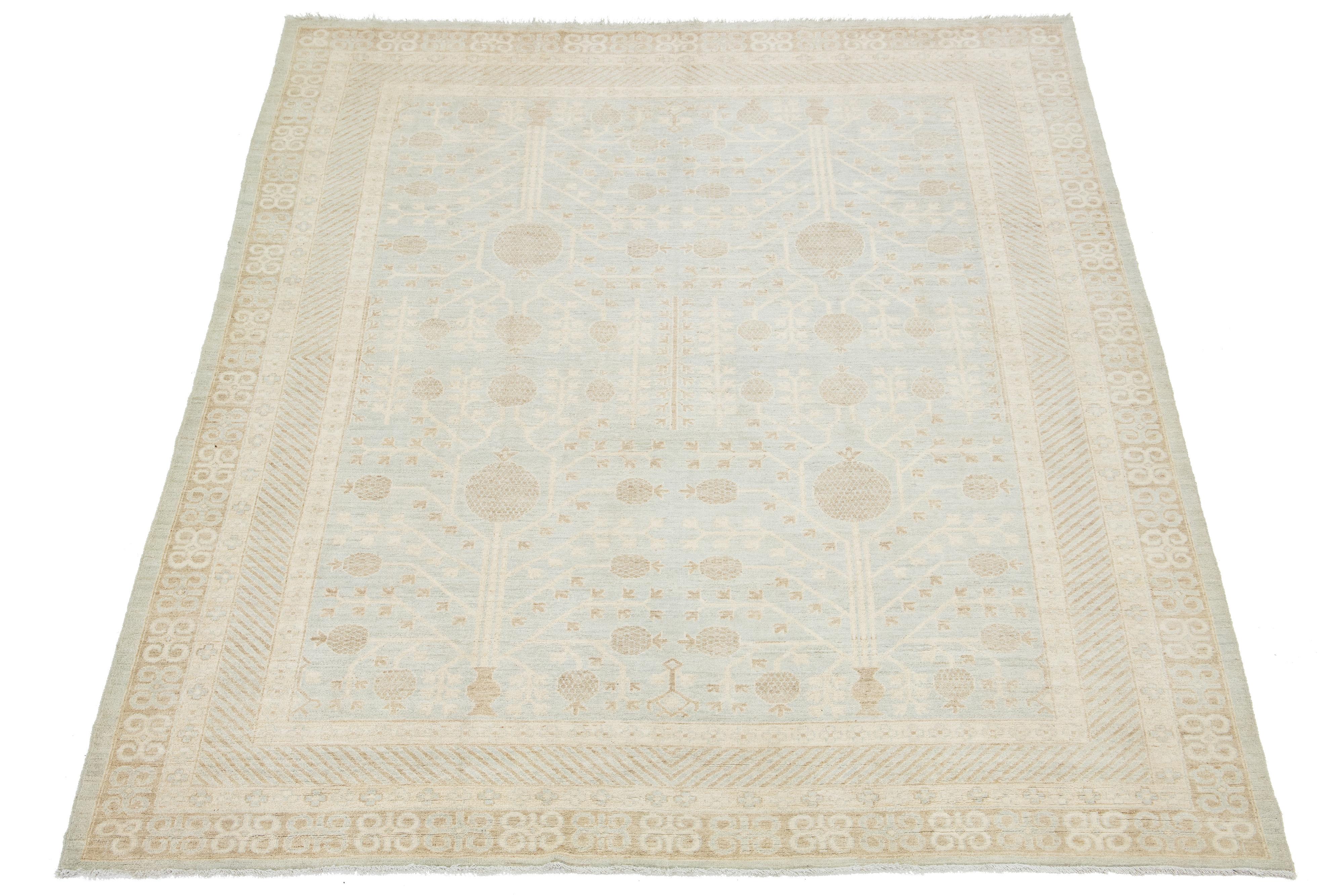 Magnifique tapis moderne en laine nouée à la main, de style Khotan, avec un champ bleu clair. Cette pièce présente un cadre conçu avec des accents gris clair et beige dans un magnifique motif all-over.

Ce tapis mesure 9' x 11'5