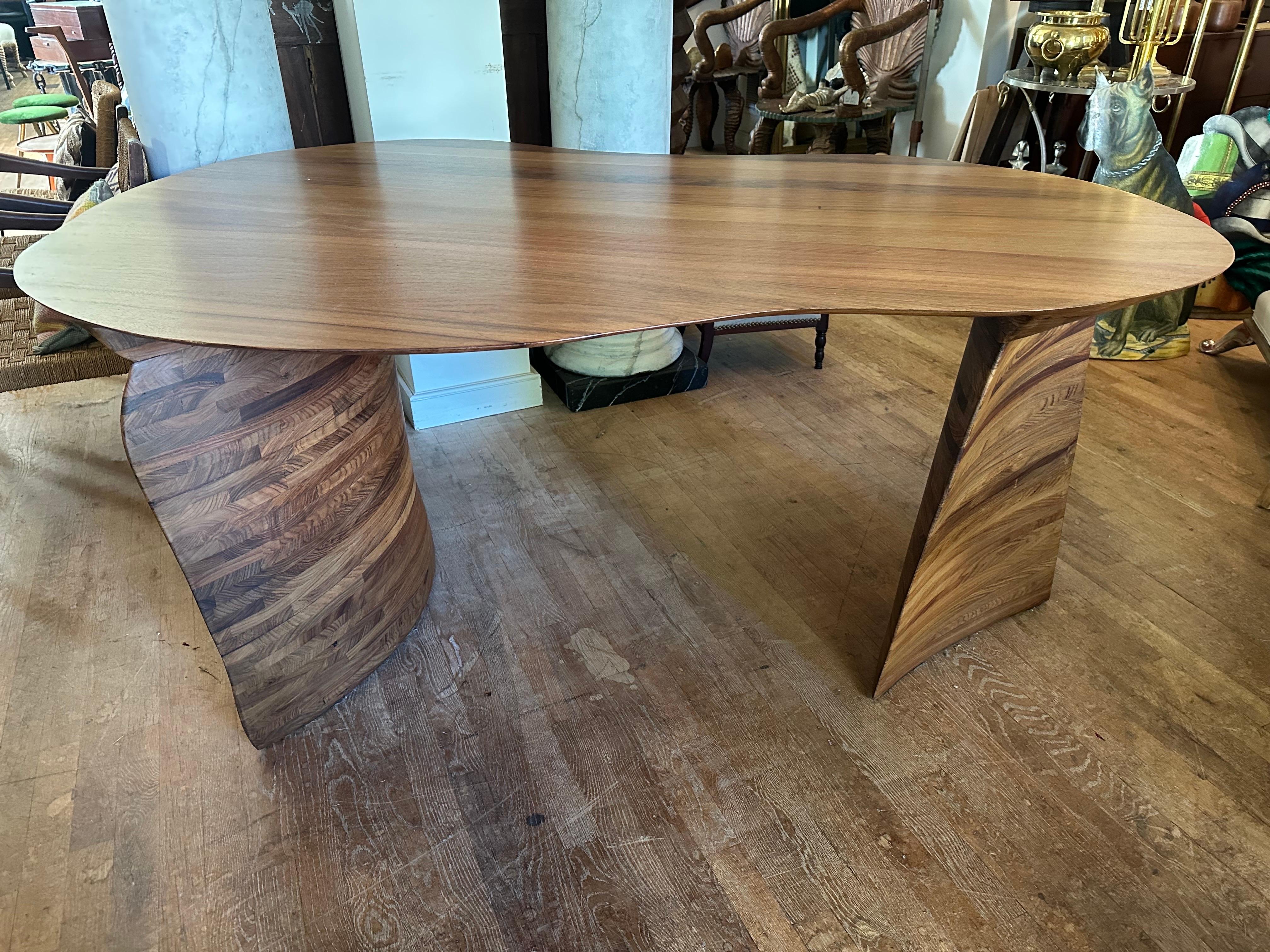 Sculptural handcrafted table or desk in a kidney shape with a beautiful layered base that resembles wings...... think crafted 
Zaha Hadid., Wendell Castle...... new satin poly finish....