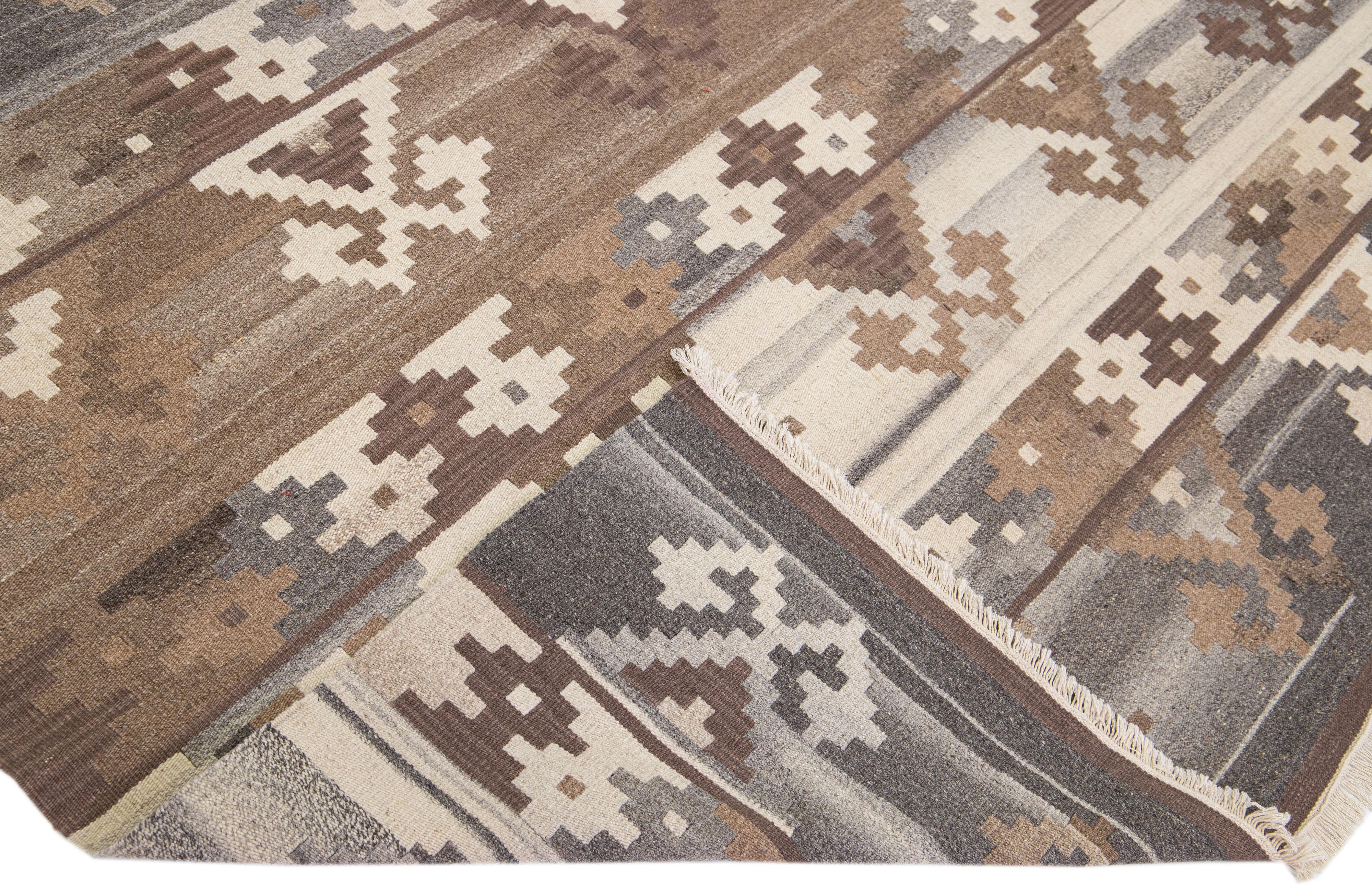 Beautiful Modern flat-weave Kilim handmade wool rug with a brown color field. This Kilim rug has gray and beige accents in a gorgeous geometric design.

This rug measures: 6'8