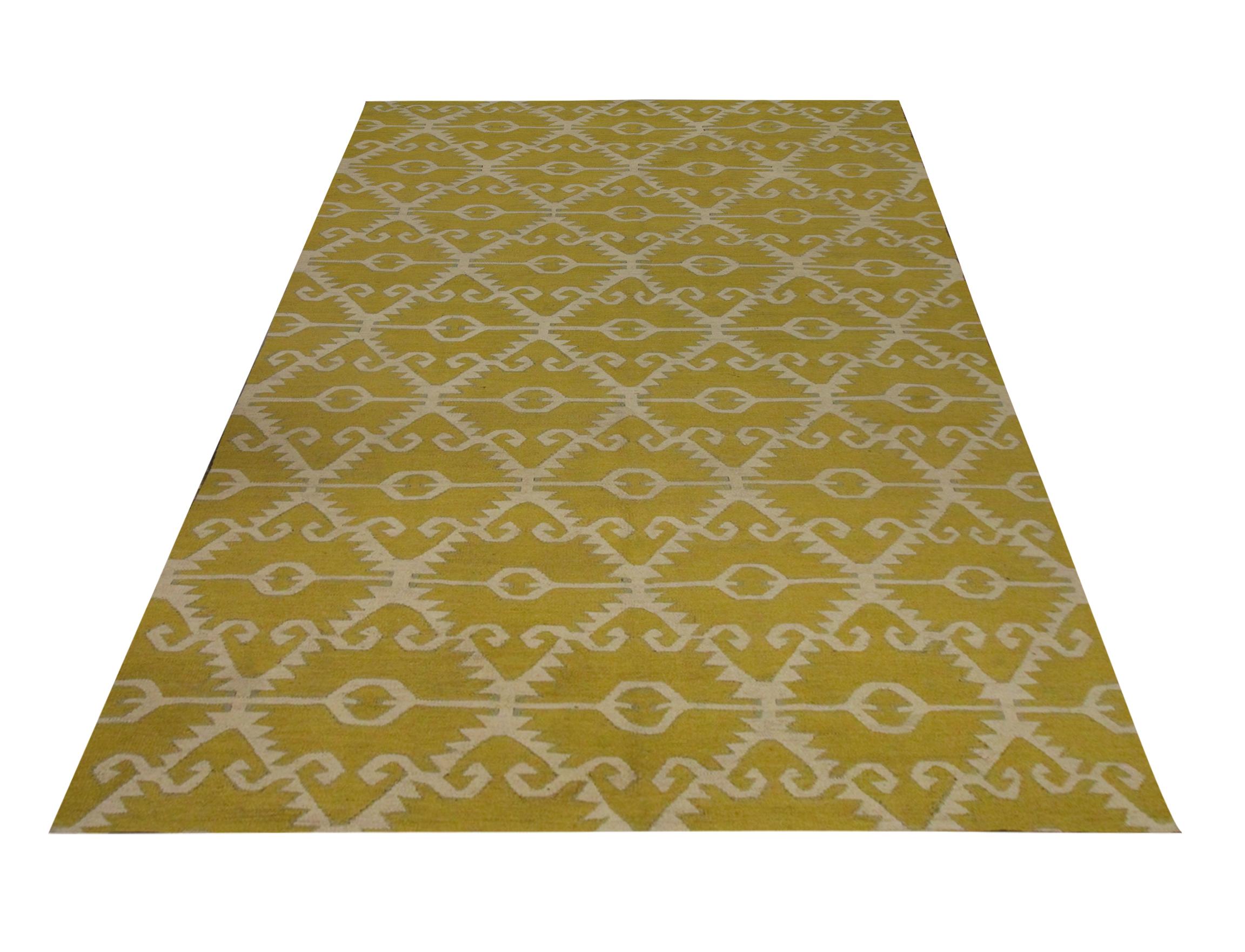 This geometric kilim is a handwoven area rug constructed in Afghanistan. The design is a bold all-over pattern woven intricately with a simple colour palette including mustard-yellow and cream. The bold design and elegant colour palette in this