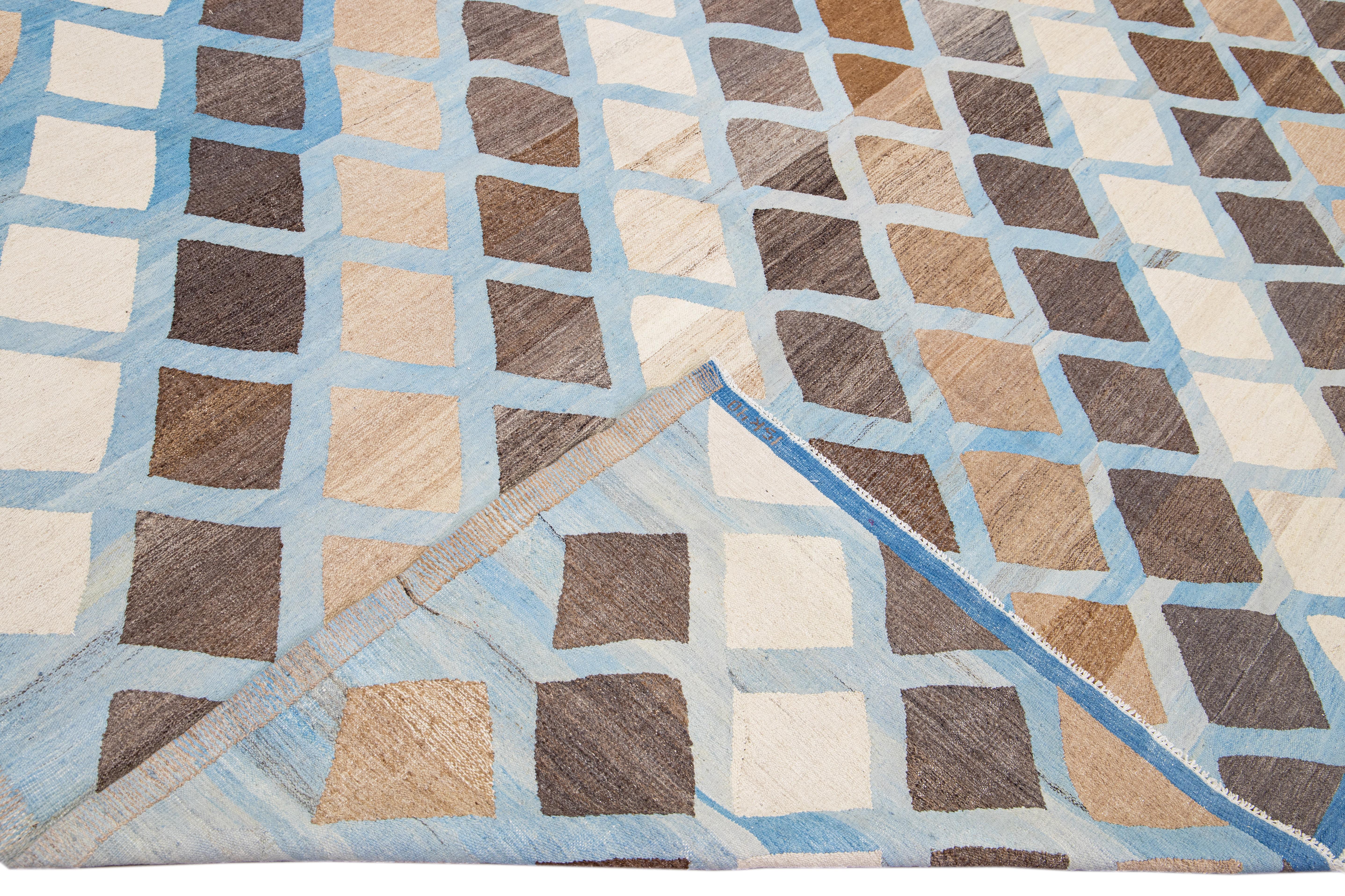 Beautiful modern flat-weave handmade wool rug. This Kilim rug has a blue field with accents of gray and brown in a gorgeous geometric expressionist design.

This rug measures: 12'5 x 17'7