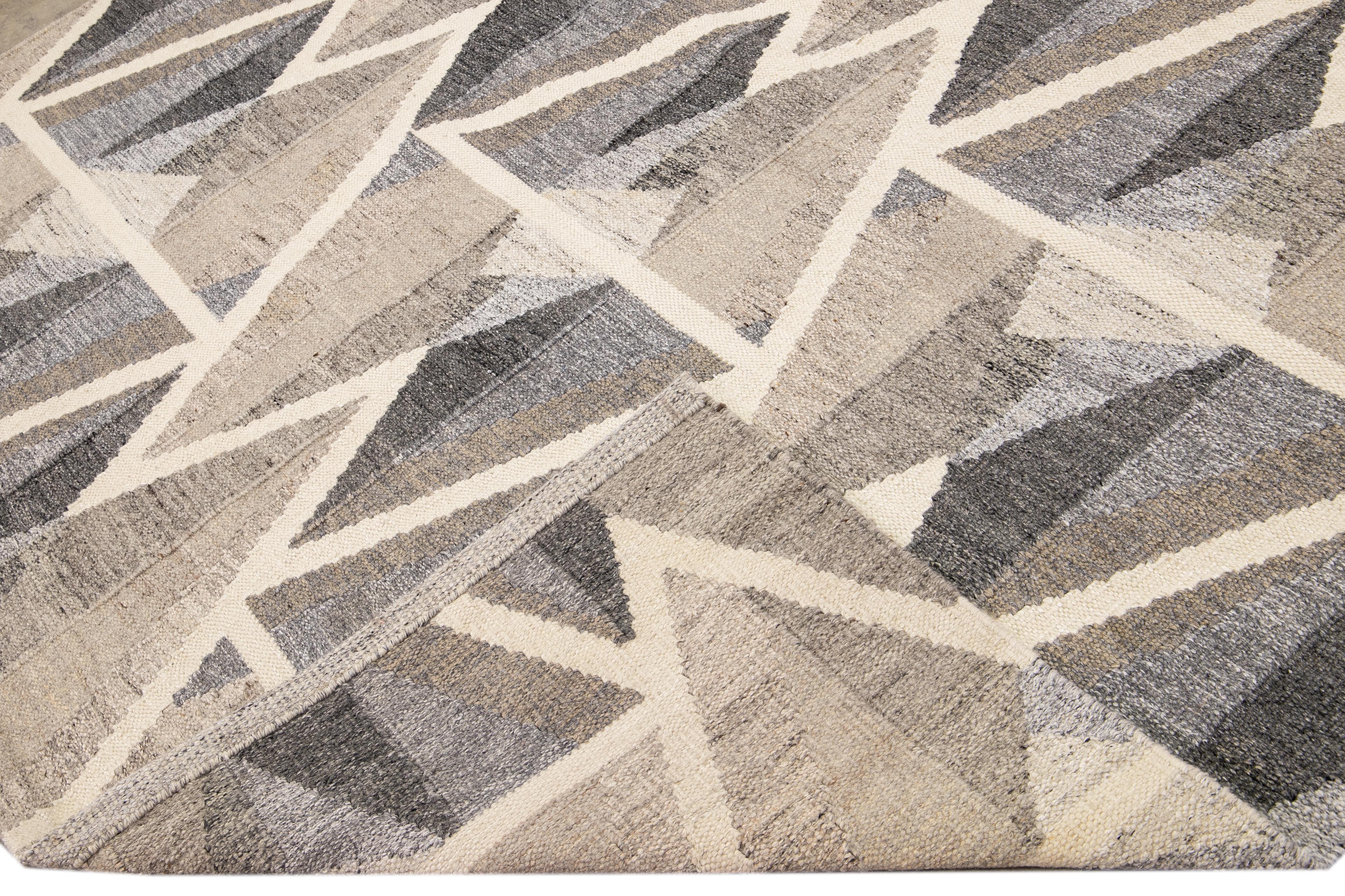 Magnifique tapis moderne en laine à tissage plat de style suédois. Ce tapis Kilim plein d'art présente un champ marron, beige et gris dans un magnifique design géométrique abstrait.

Ce tapis mesure : 9'2