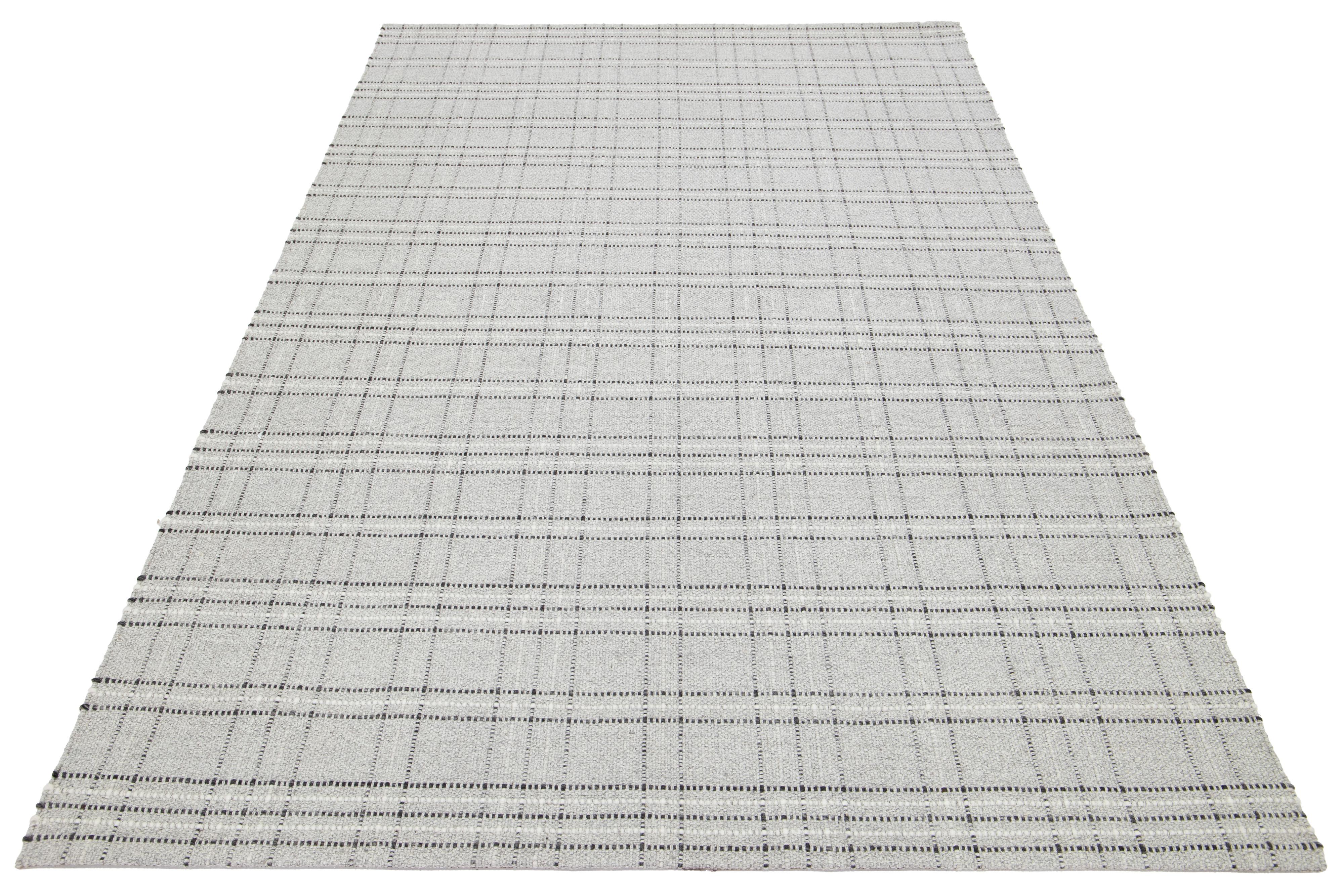 Dies ist ein schöner Kelim handgefertigt Wolle Teppich mit einem hellgrauen Feld. Dieser moderne Flachgewebe-Teppich aus unserer Nantucket-Kollektion hat einen elfenbeinfarbenen Akzent und ein wunderschönes geometrisches Allover-Muster.

Dieser