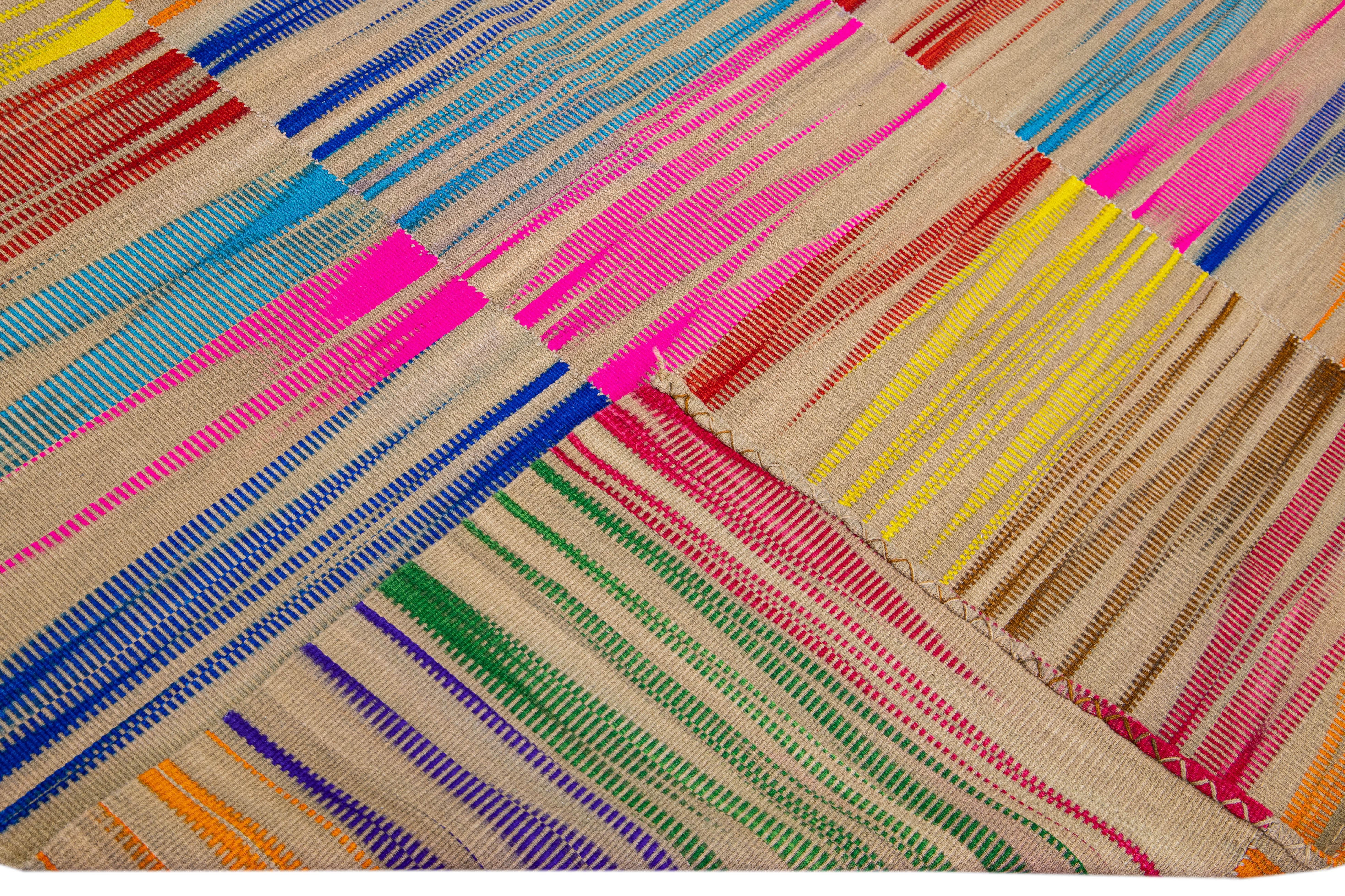 Schöner moderner flachgewebter Kilim-Wollteppich mit hellbraunem Feld. Dieses Kunstwerk hat einen mehrfarbigen Akzent in einem herrlichen abstrakten Retro-Muster-Design.

Dieser Teppich misst: 7' x 9'5