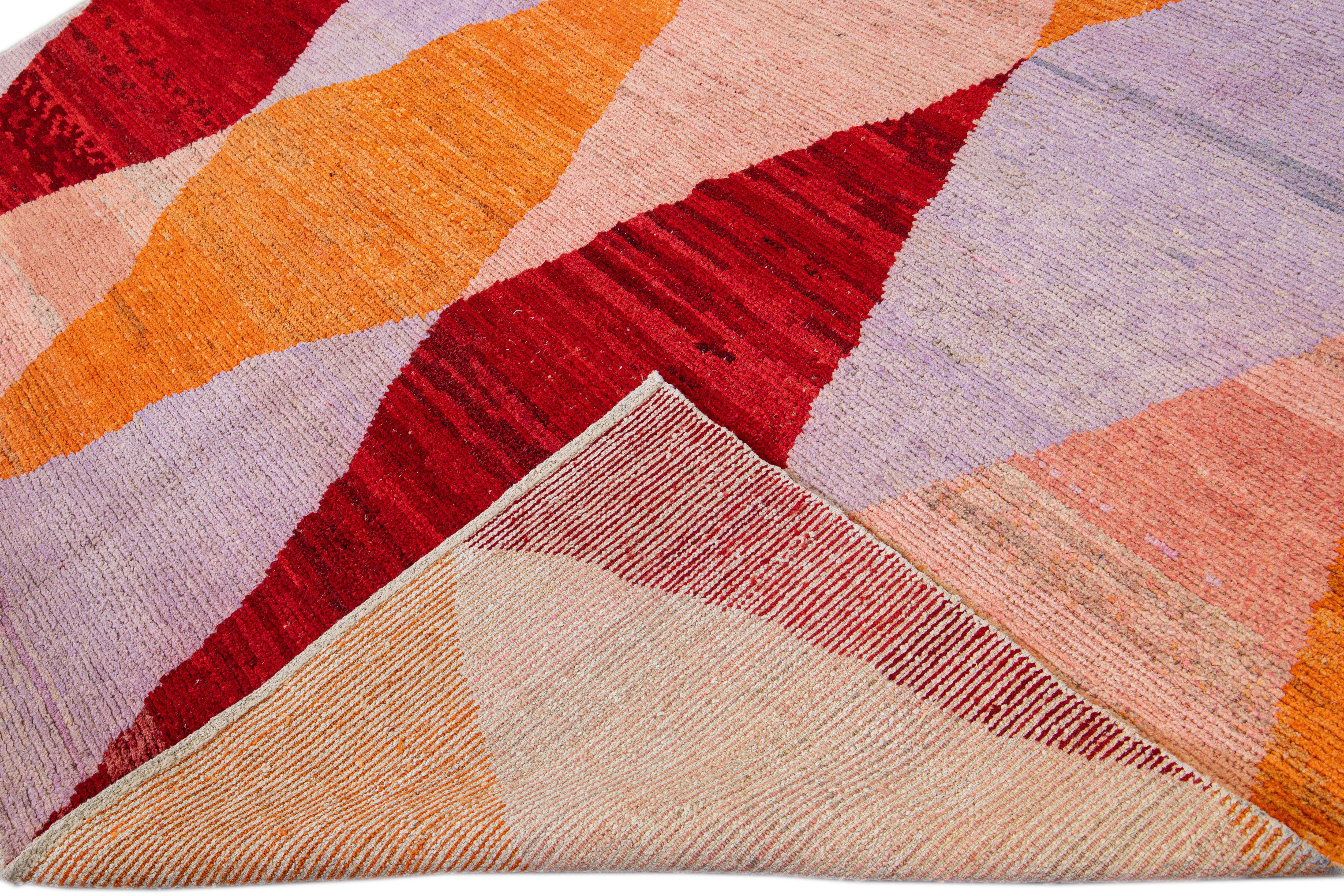Beautiful modern Turkish wool rug with an orange, red, beige, and purple field layout in a gorgeous geometric diamond pattern design.

This rug measures: 8'6