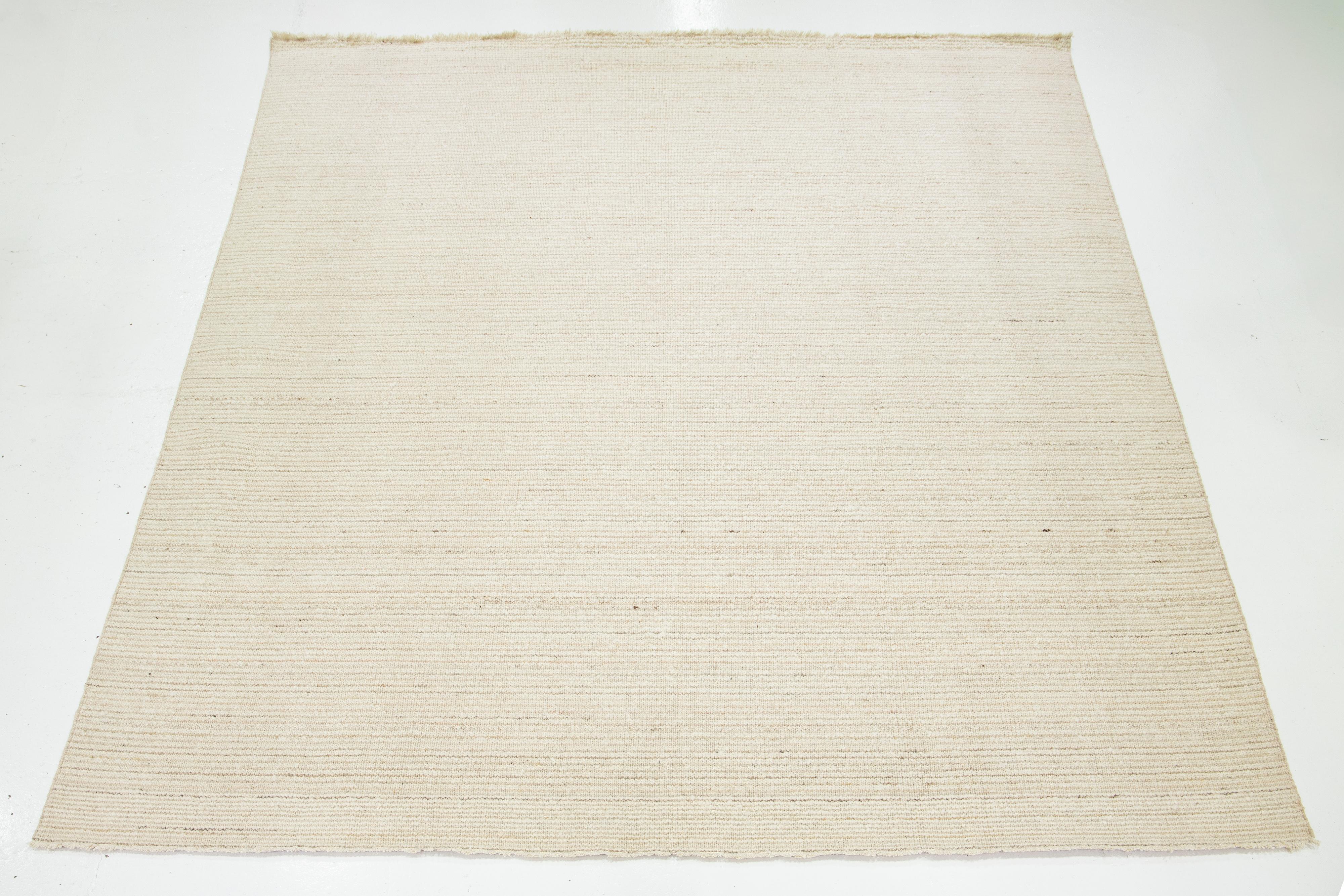 Ein zeitgenössischer flachgewebter Kelimteppich mit einem beigen Feld und hellbraunen Akzenten in einem geometrischen Allover-Muster.

Dieser Teppich misst 12' x 15'.