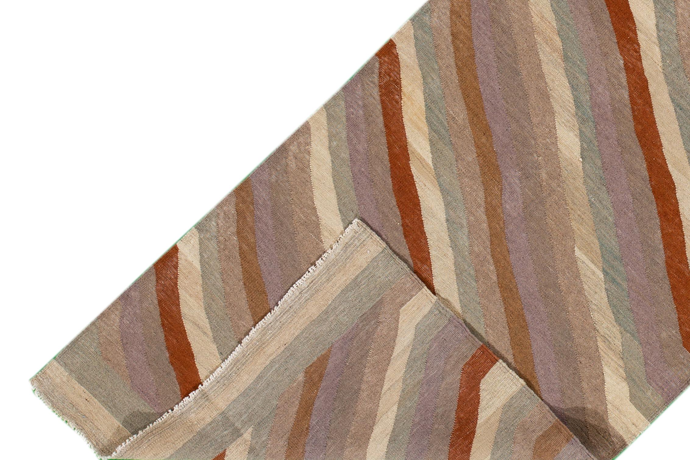 Un tapis Kilim moderne tissé à la main avec un motif linéaire. Ce tapis mesure 3'3
