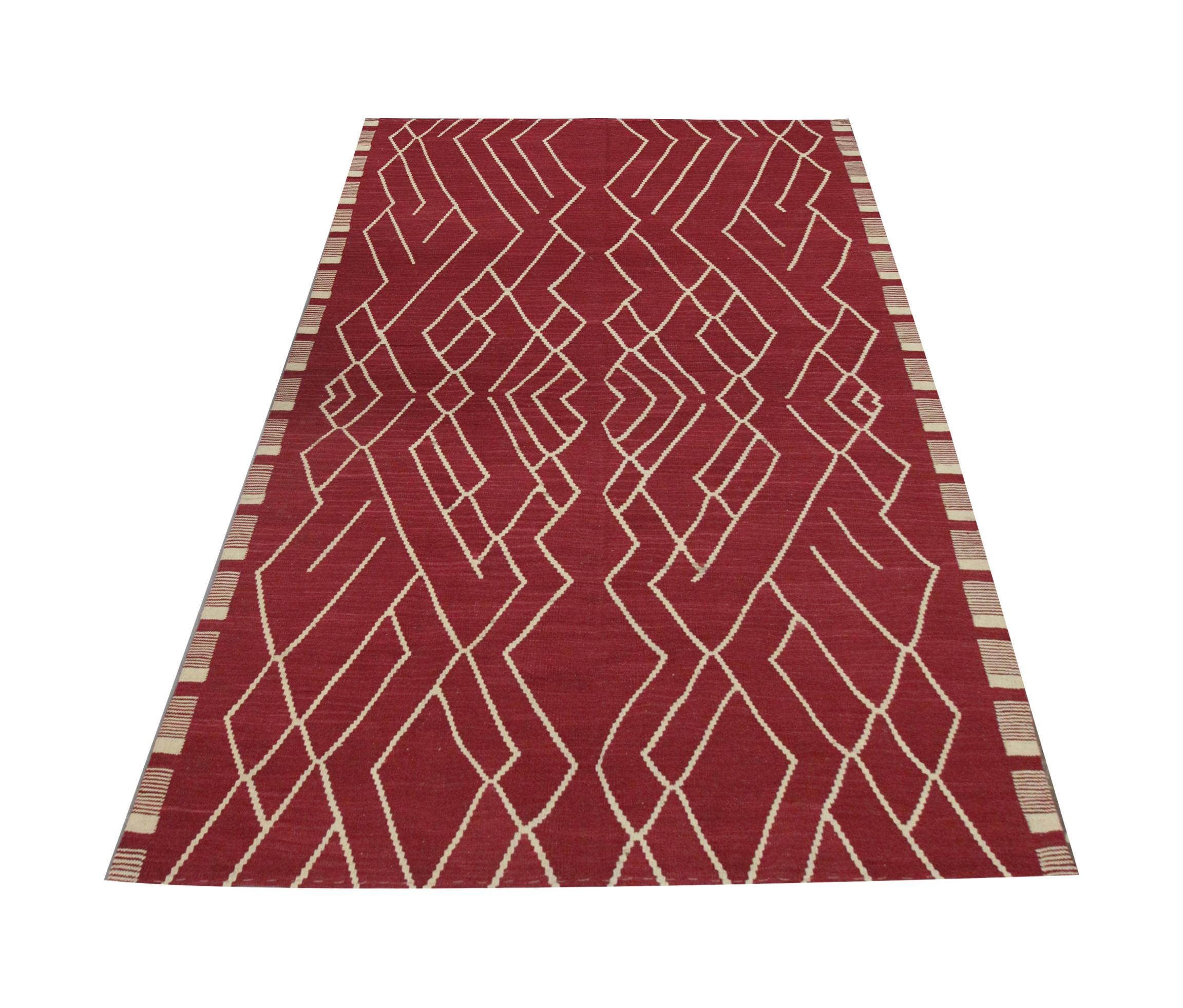 This modern wool ara rug is a flatwoven Kilim, constructed in Afghanistan. The patterns featured are symmetrically woven and from certain angles appear to emulate a mountainous landscape. The linear patterns are woven in cream and contrast with the