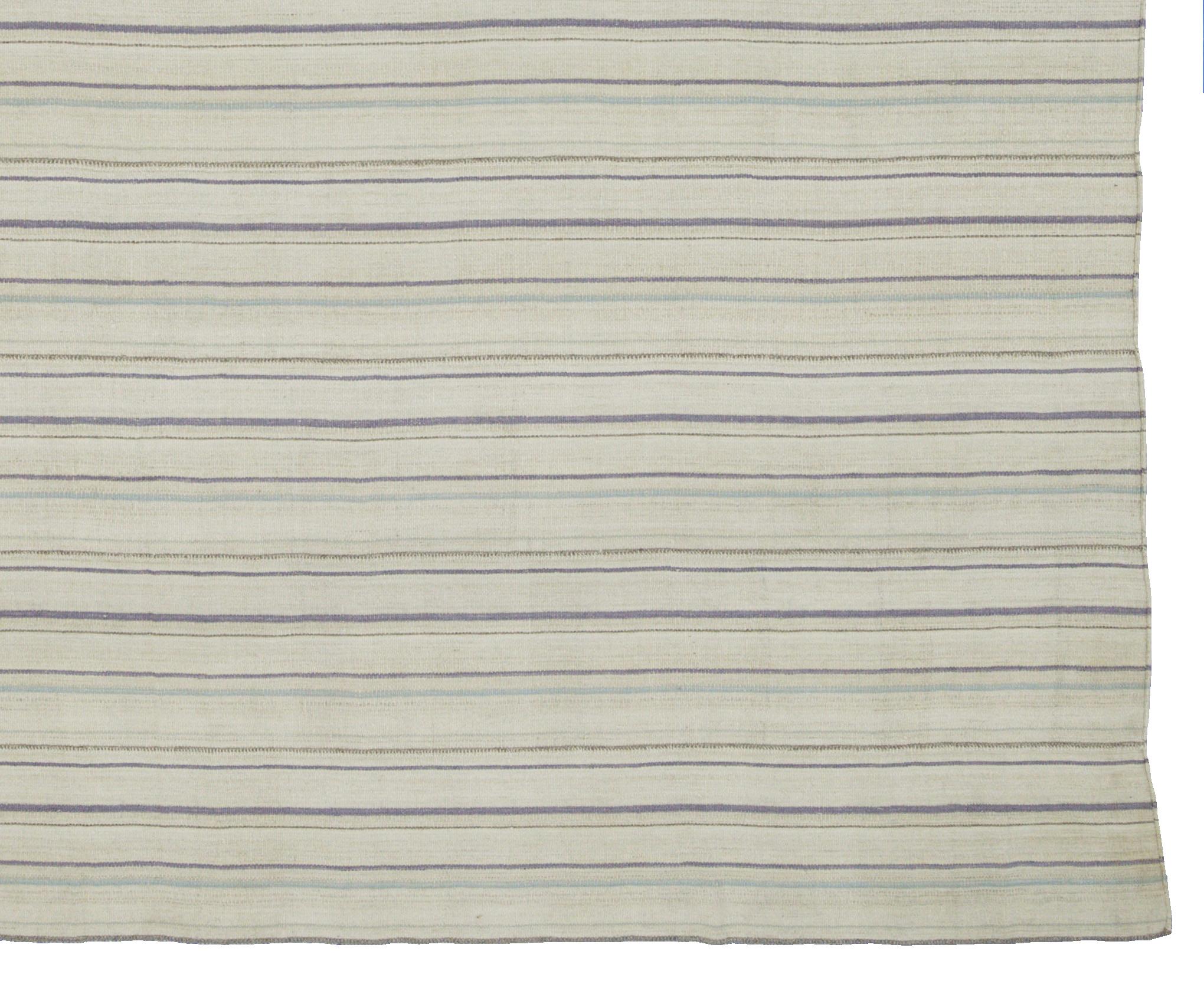 A new production Turkish rug handwoven from the finest sheep’s wool and colored with all-natural vegetable dyes that are safe for humans and pets. It’s a traditional Kilim flat-weave design featuring a lovely ivory field with gray, blue and purple