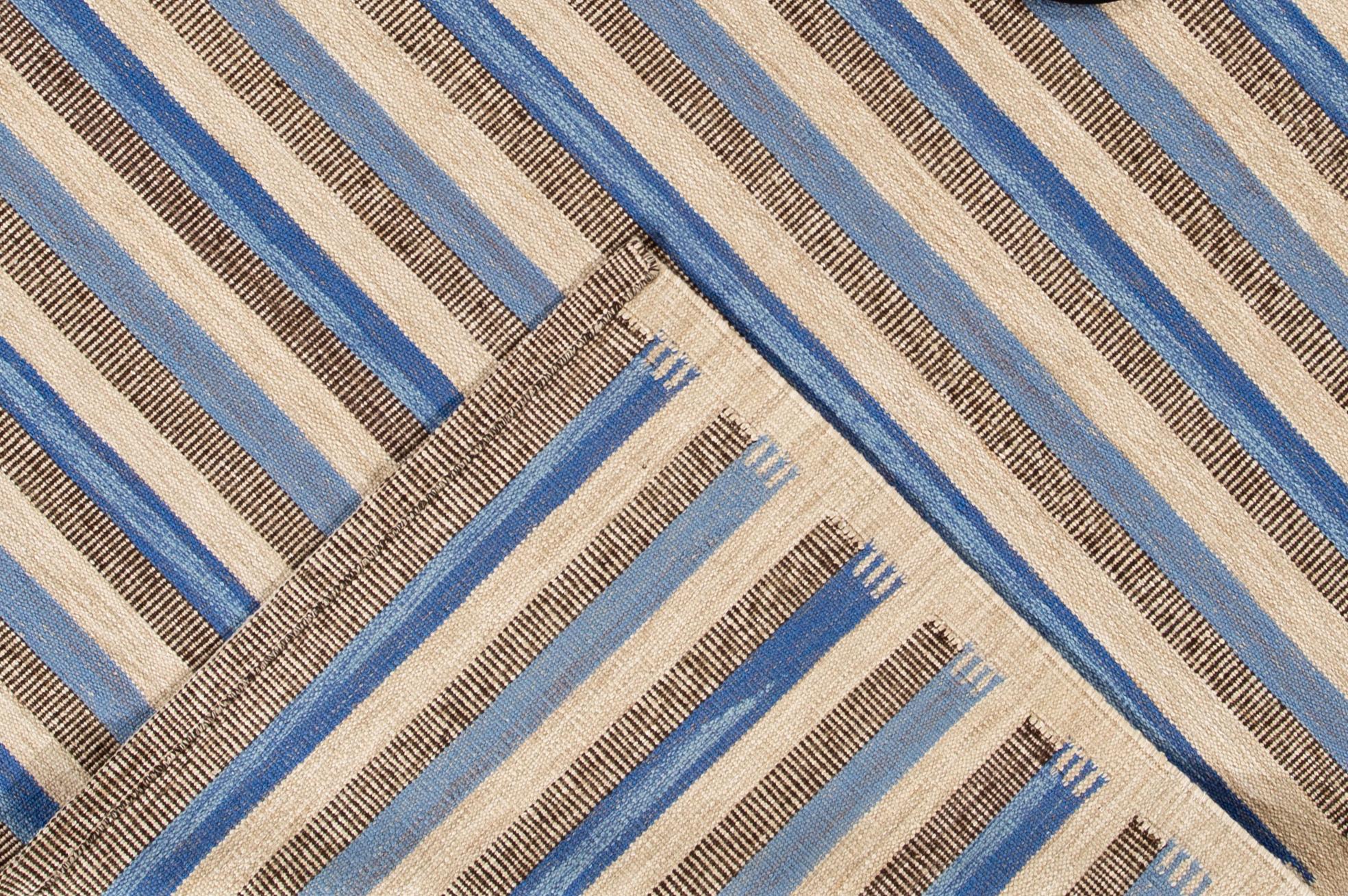 A hand-knotted modern Swedish-Style rug with a tan field, beige and blue accents in a stripe design.

This rug measures 8' 2