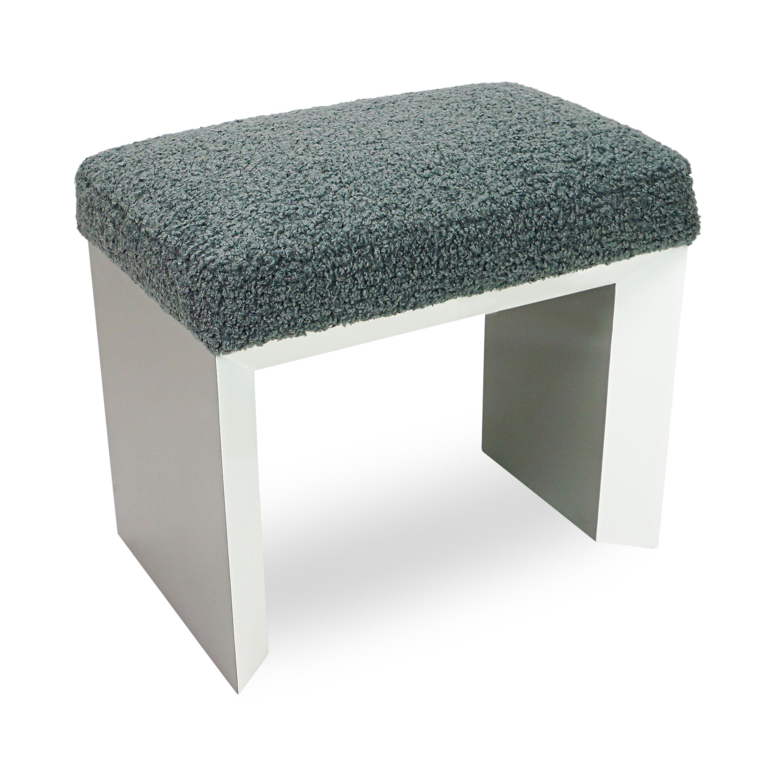 A new take on a classically shaped modern bench with its 3 inch beveled white lacquered base contrasting with a soft wooly grey upholstered seat, this piece is an excellent addition for extra seating and will fit into any modern to eclectic styled