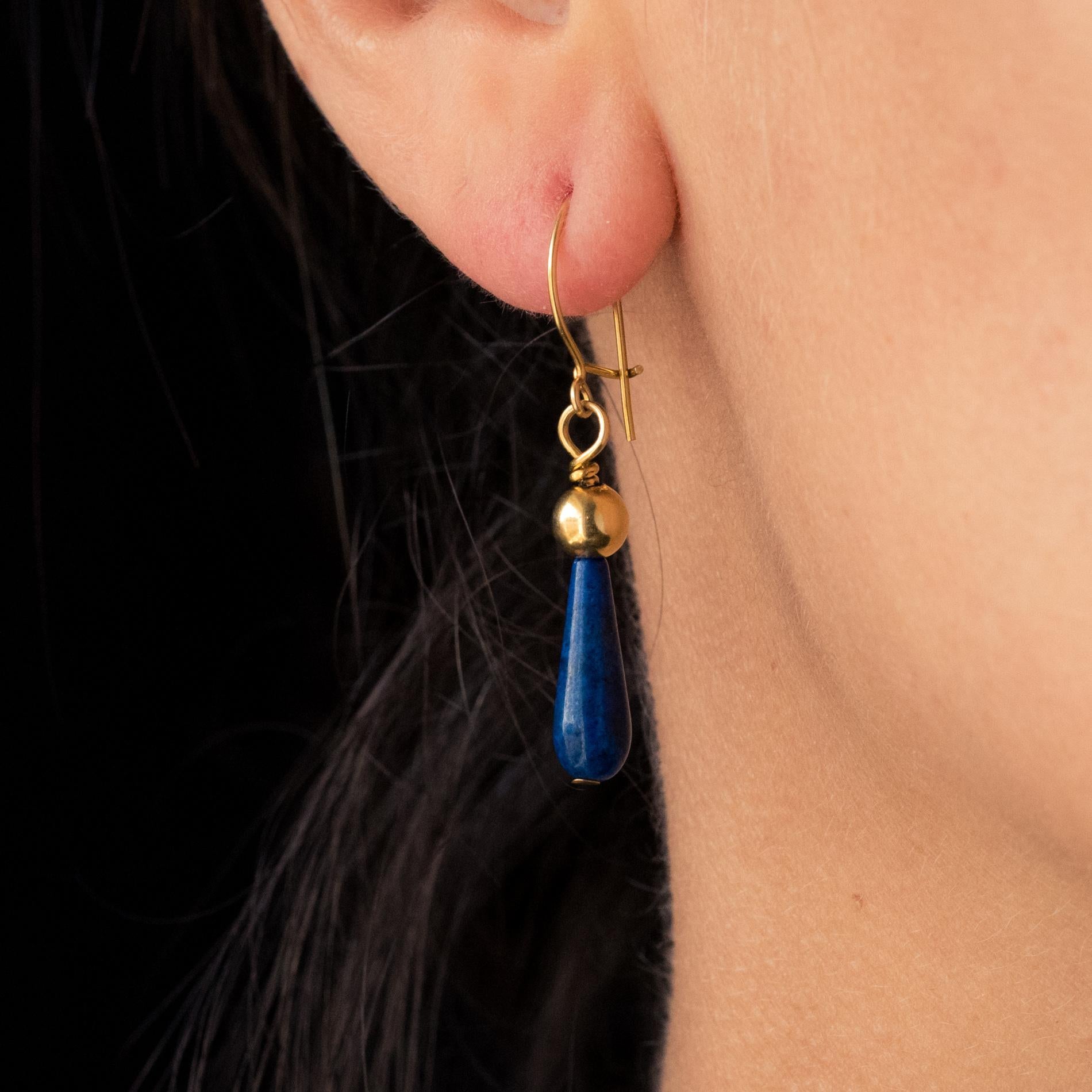 For pierced ears.
Pair of pendant earrings in 18 karat yellow gold.
Each earring is adorned with a long drop of lapis lazuli, topped with a gold pearl.
Length : 3.8 cm.
Total weight of the jewel : approximately 1.6 g.
Second-hand earrings -