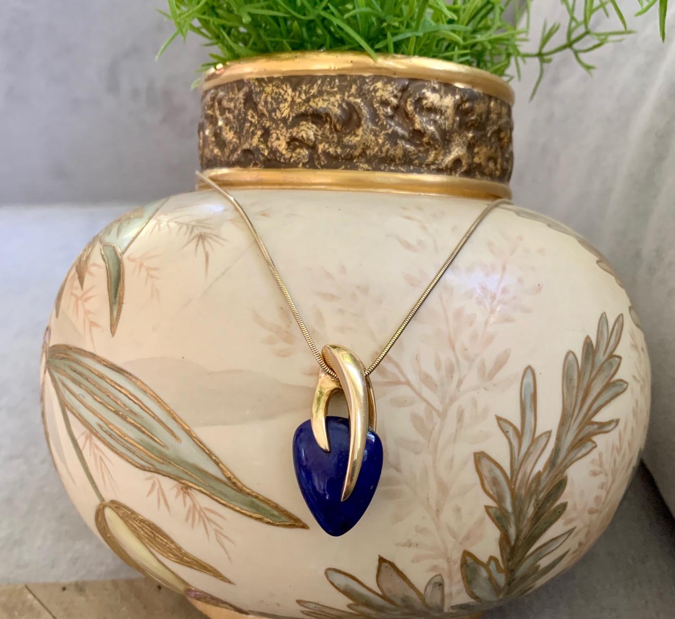 This beautiful blue Lapis Lazuli stone is set in a claw-like setting of 18 karat Gold and signed by Kria. It hangs from a 14 karat snake chain.

Stamped KRIA of NY

Chain Length: 18