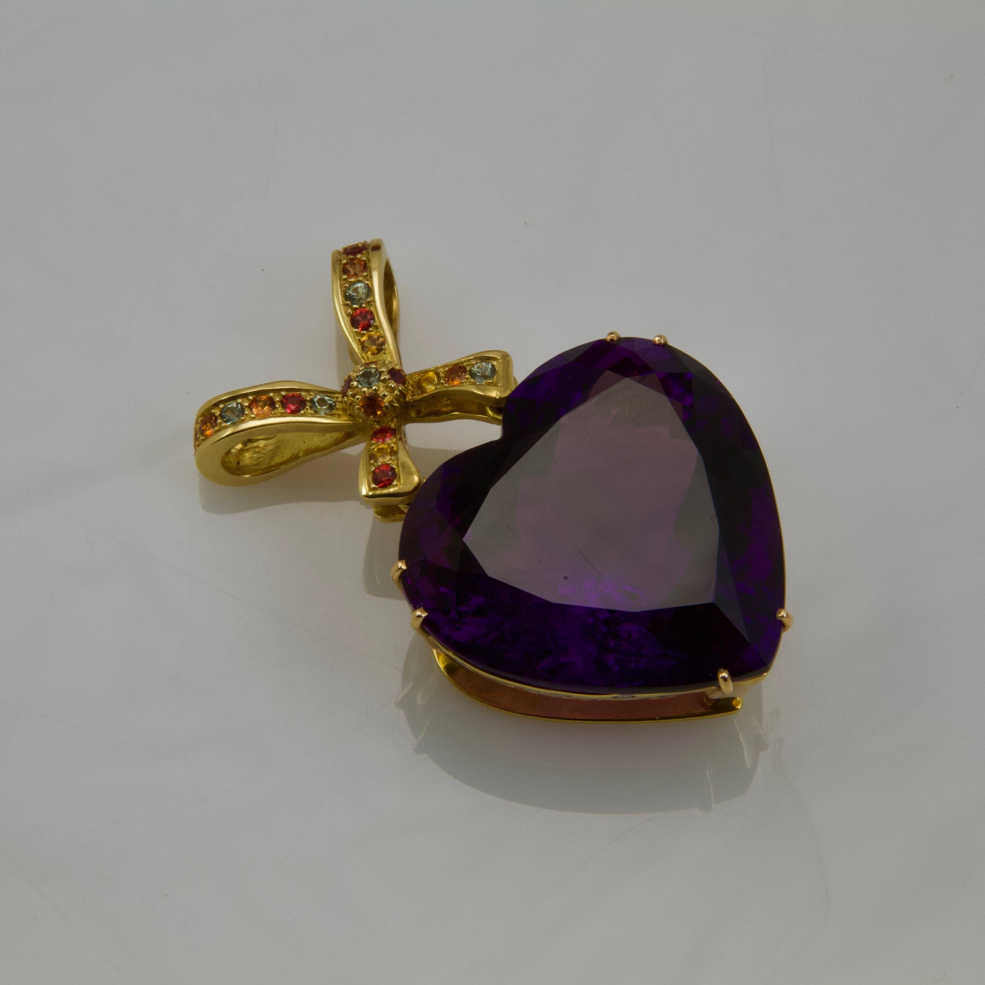 A large amethyst heart-shaped pendant  on a 18kt yellow gold mount set on the two sides with round diamonds and on the bow with coloured stones.
Amethyst weight almost 150 carats
Maker's mark:  JL
French assays mark. 
Made in seventies. 
Perfect