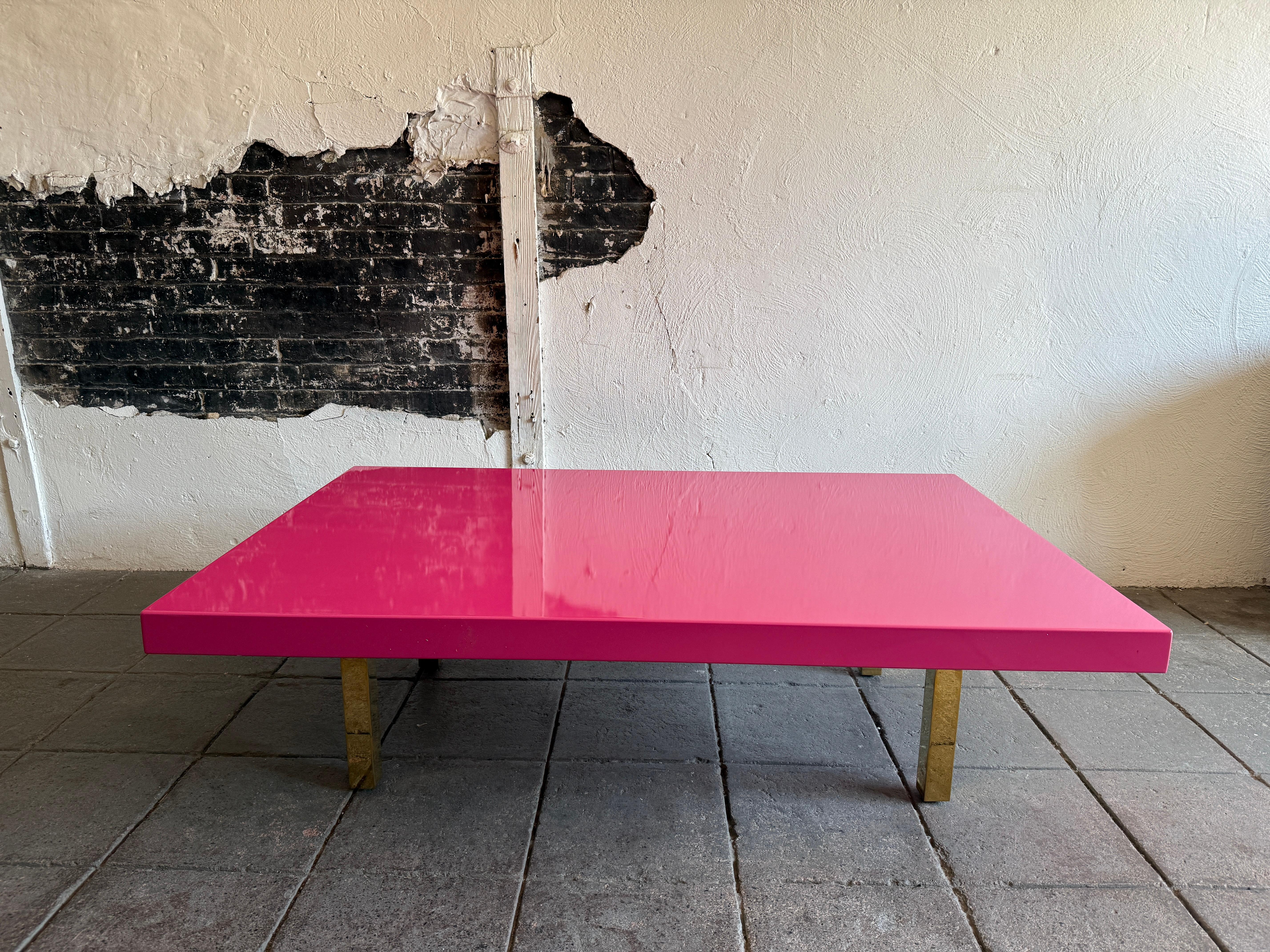 Modern large low bright pink high gloss lacquer coffee table with brass legs. In the style of post modern. Very fun colorful low coffee table. Sits on (4) square tube brass or gold chrome plated legs. Very heavy and sturdy table. Custom made circa