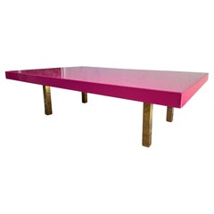 Grande table basse rose vif et brillante, avec pieds en laiton