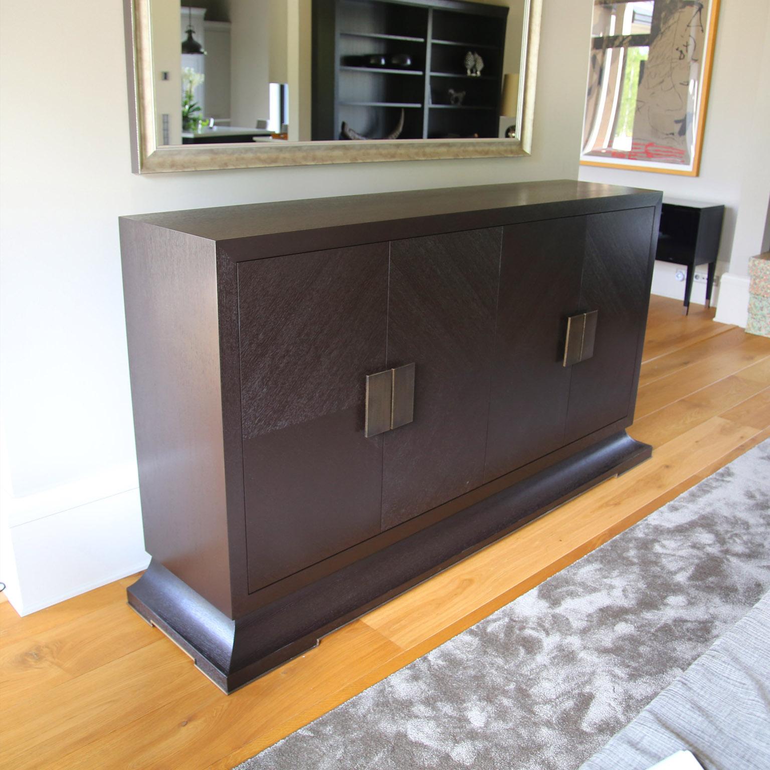 A beautiful sideboard with oakwood inlaying doors, and stunning aged brass handles. The oakwood inlaying is made in a special marquetry technique and finished with 2 coats of anti scratch rich dark brown paint. Combining luxury design with brilliant