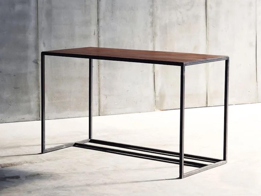 Questa scrivania in pelle belga è una miscela perfetta di artigianato e minimalismo moderno. La scrivania presenta un piano in pelle conciata al vegetale, meticolosamente intarsiato su un'elegante base in acciaio. La morbida superficie in pelle