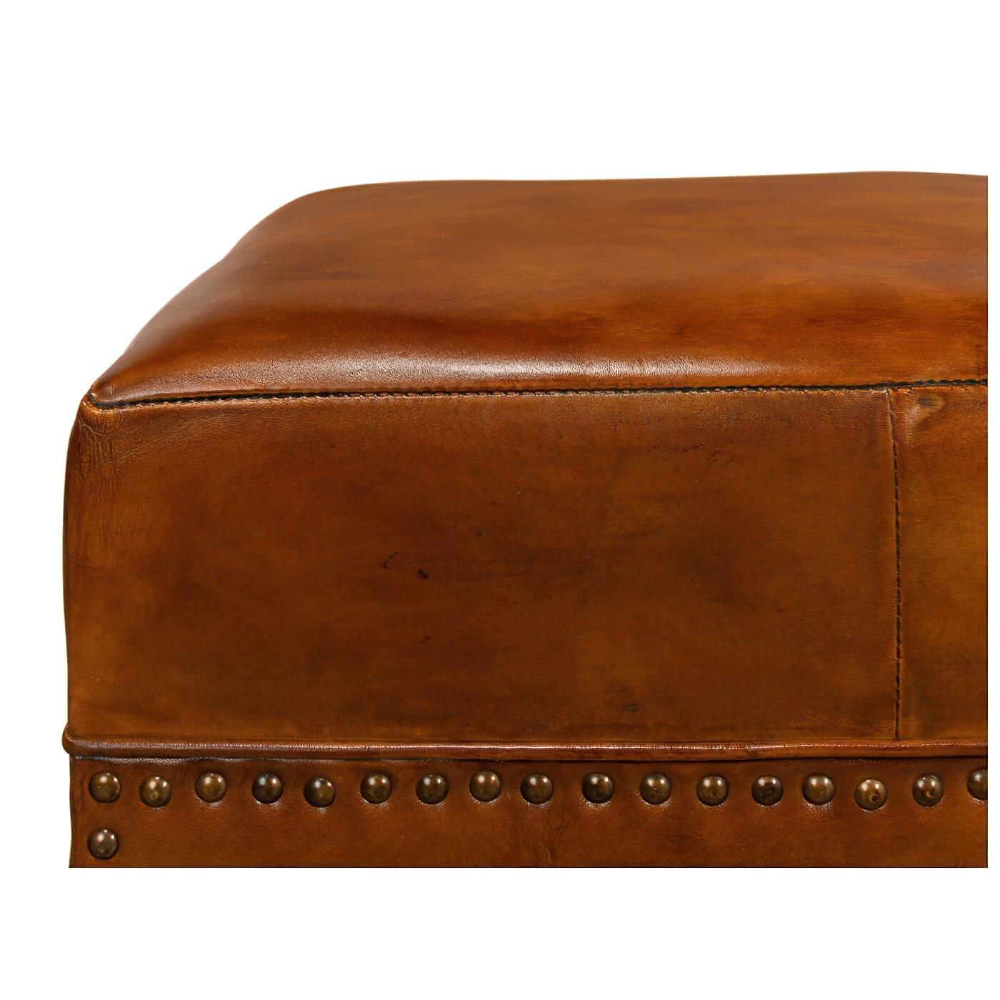 A modern leather arch base ottoman. Crafted in rich brown leather, this ottoman is accented with small brass nailhead trim. The unique open decorative arched base makes this small stool a true conversation piece. 

Its practical and comfortable