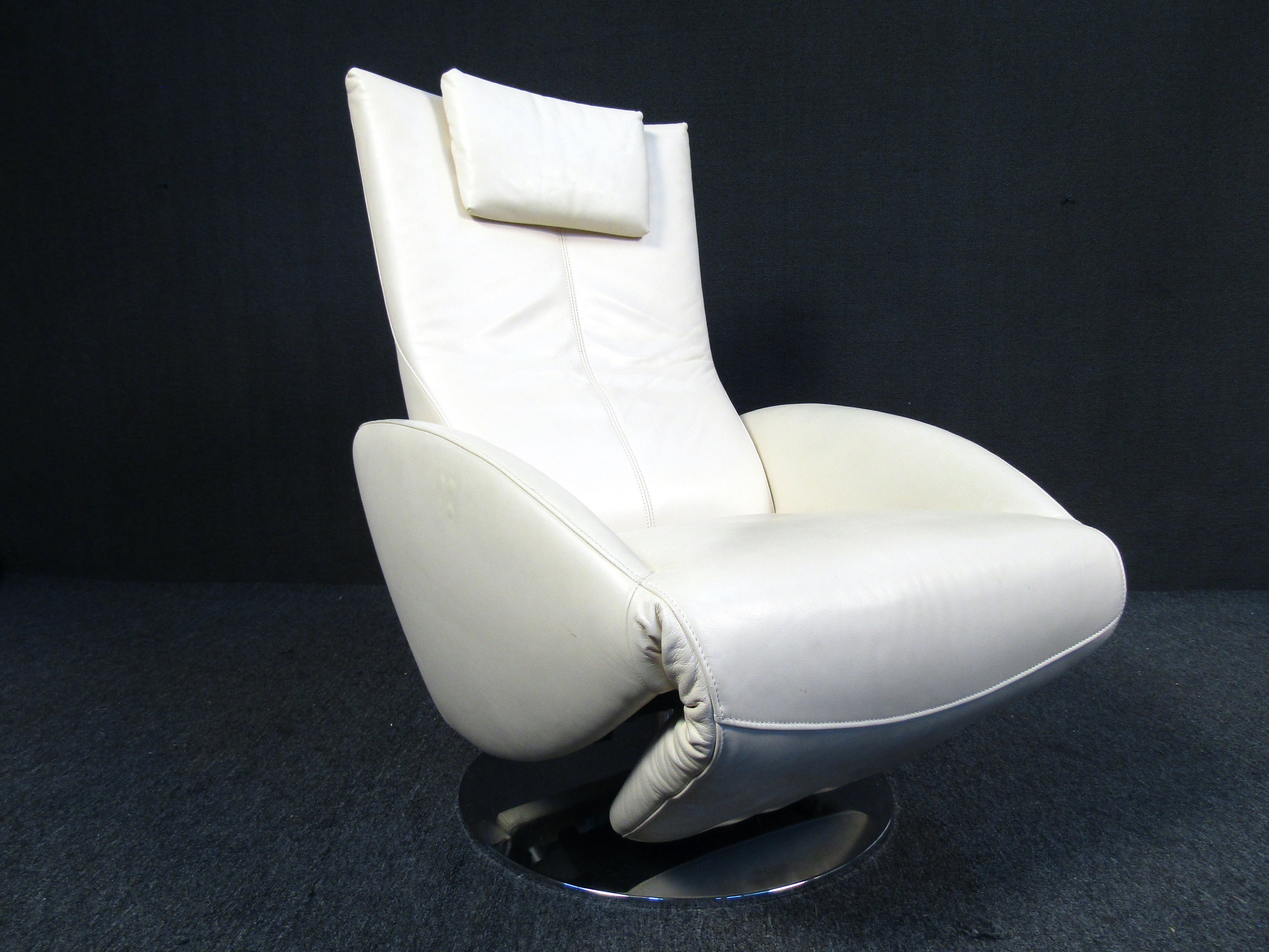 Stylish leather multi function chair by Swiss company FSM. This chair features quality white leather upholstery, round stainless steel base, and electronic reclining functionality with button controls positioned on the arm. A handsome chair that