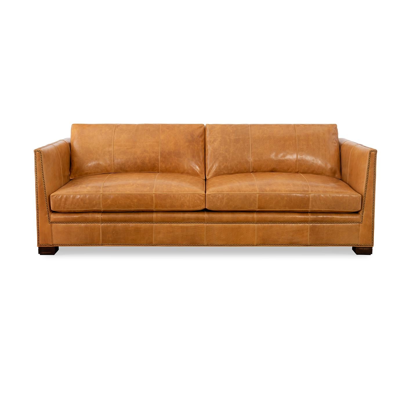 A Modern leather upholstered sofa with sleek modern lines and raised on bold block feet. Two long loose pillow backs with two long comfort down seat cushions.

Shown in Madrid Spice leather with brass nailhead trim details outlining the angled arm