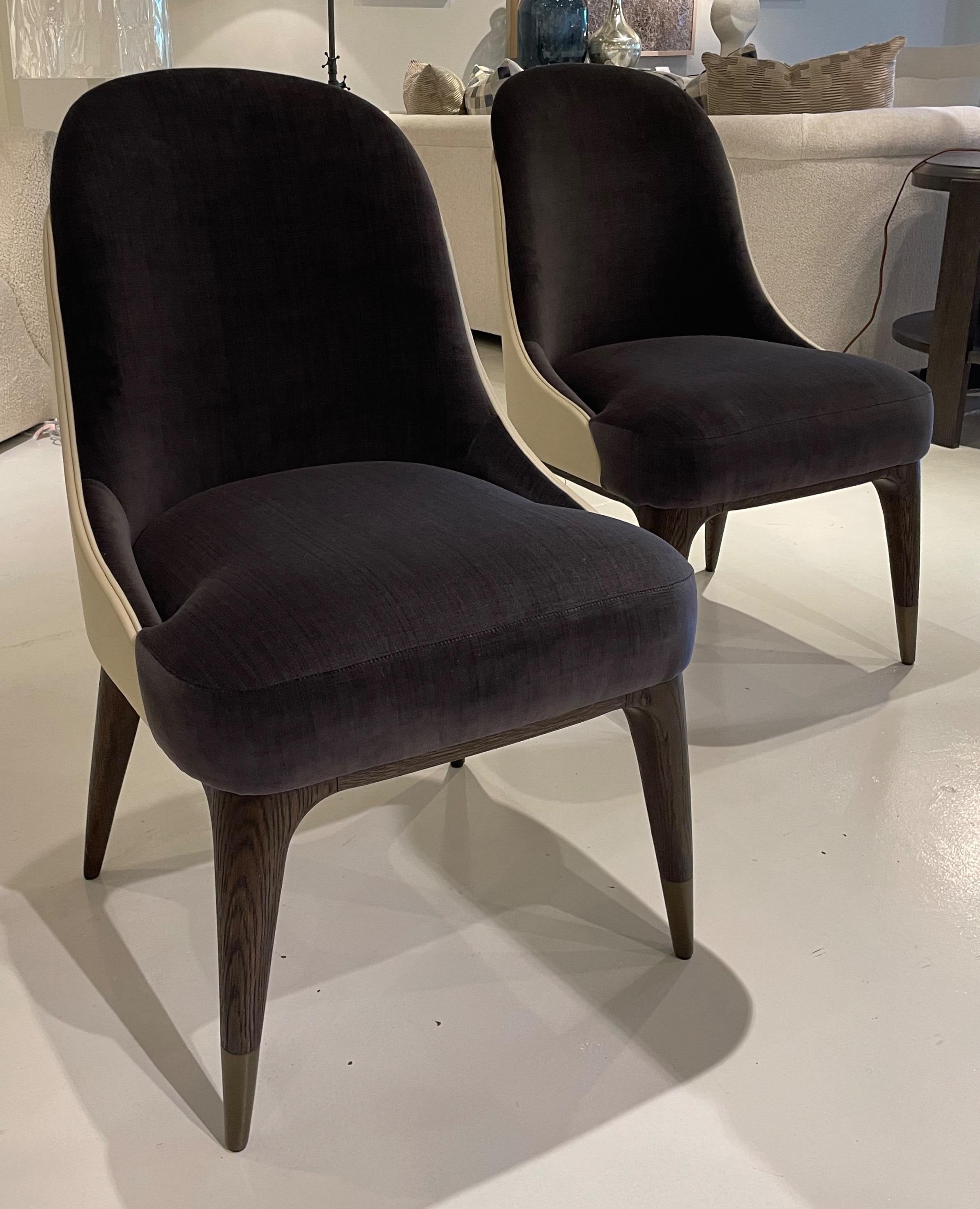 Showroom new - pair of Theodore Alexander covet dining chair II designed by Steve Leung. Ivory leather wrapped tailored back. Seat and in-back are covered in a luxurious grey velvet. Solid brushed beech legs in a Cigar Club finish with bronze