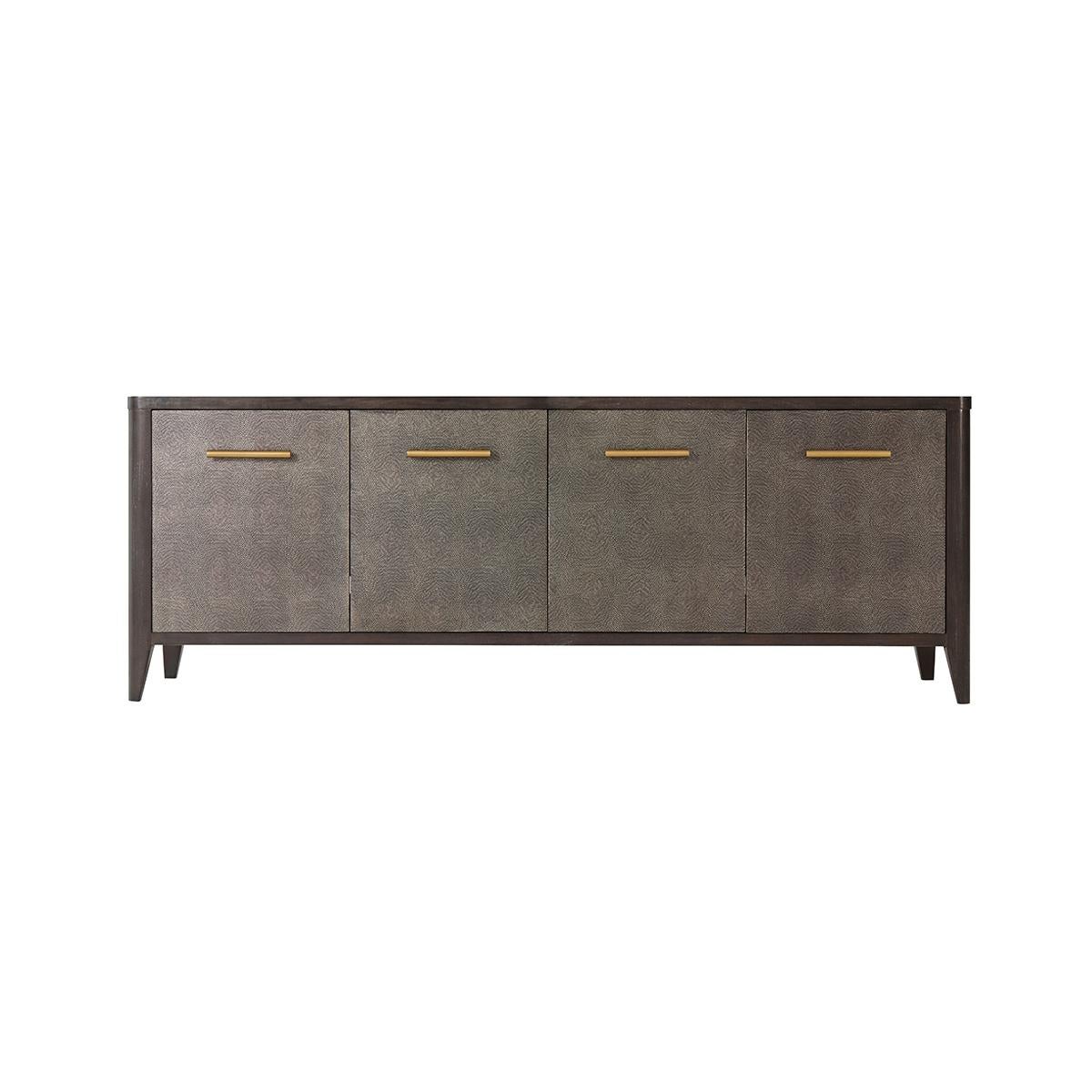 Modern leather wrapped media cabinet, in our Rowan finish. The tempest finish embossed leather doors and sides, with four doors enclosing shelves with brushed brass finish handles raised on flared tapered legs.

Dimensions: 66.5