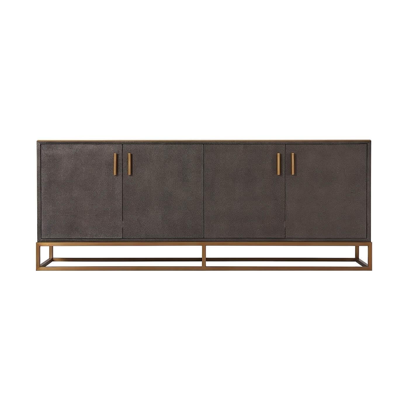 Modern leather wrapped media console A shagreen embossed leather wrapped cabinet in grey tempest finish with four cabinet doors enclosing shelves on a brass open cube base with polished nickel molding and handles.

Dimensions: 70.75