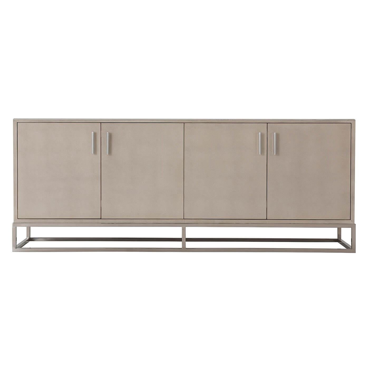 Modern leather wrapped media console. A shagreen embossed leather wrapped cabinet in an overcast finish with four cabinet doors enclosing shelves on a polished nickel open cube base with polished nickel molding and handles.

Dimensions: 70.75