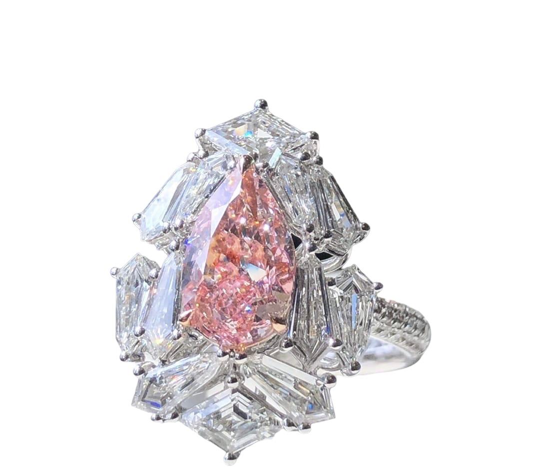 We invite you to discover this rare and modern art deco ring set with a 2.01 carat GIA certified Light Pink pear diamond accented with beautiful Lozenge Step cut diamond colorless diamonds. Its modern and refined design as well as the cut of its